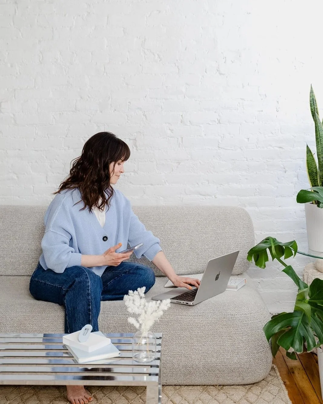 Melissa Kelly web designer for therapists typing on laptop at Go Bloom Creative