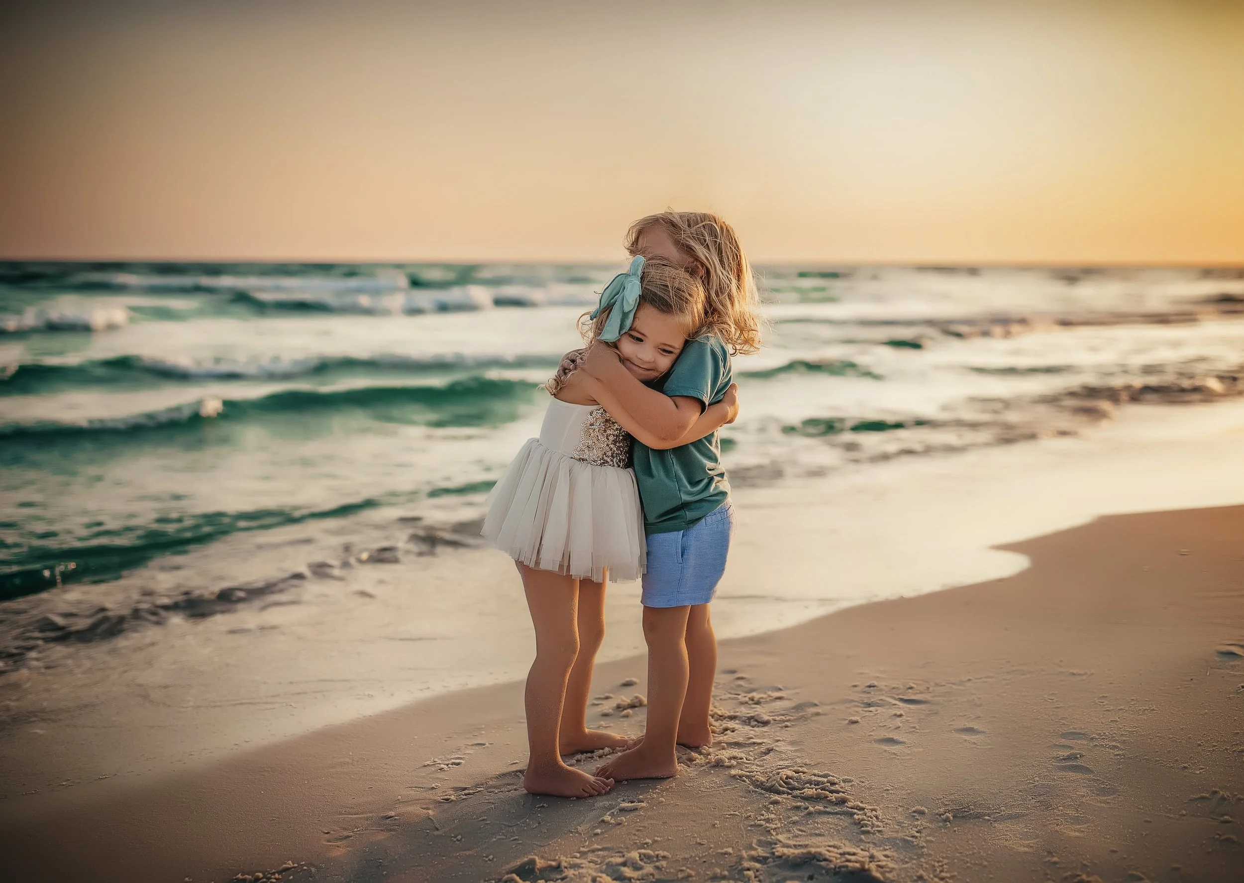 Siblings hugging on the beach at sunset during 30A Rosemary Beach family photo session