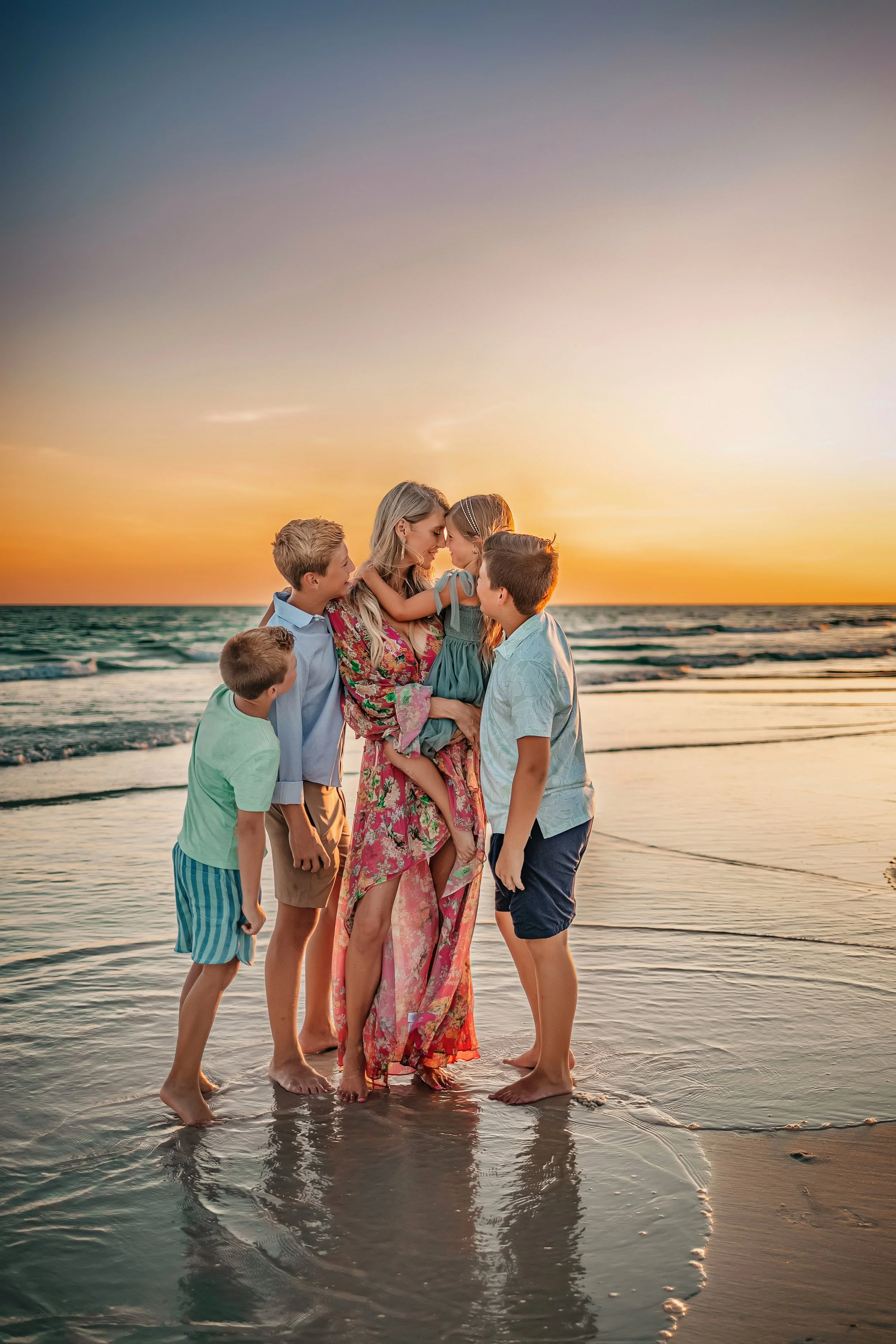 Mother embracing her children during her sunset family session in Destin