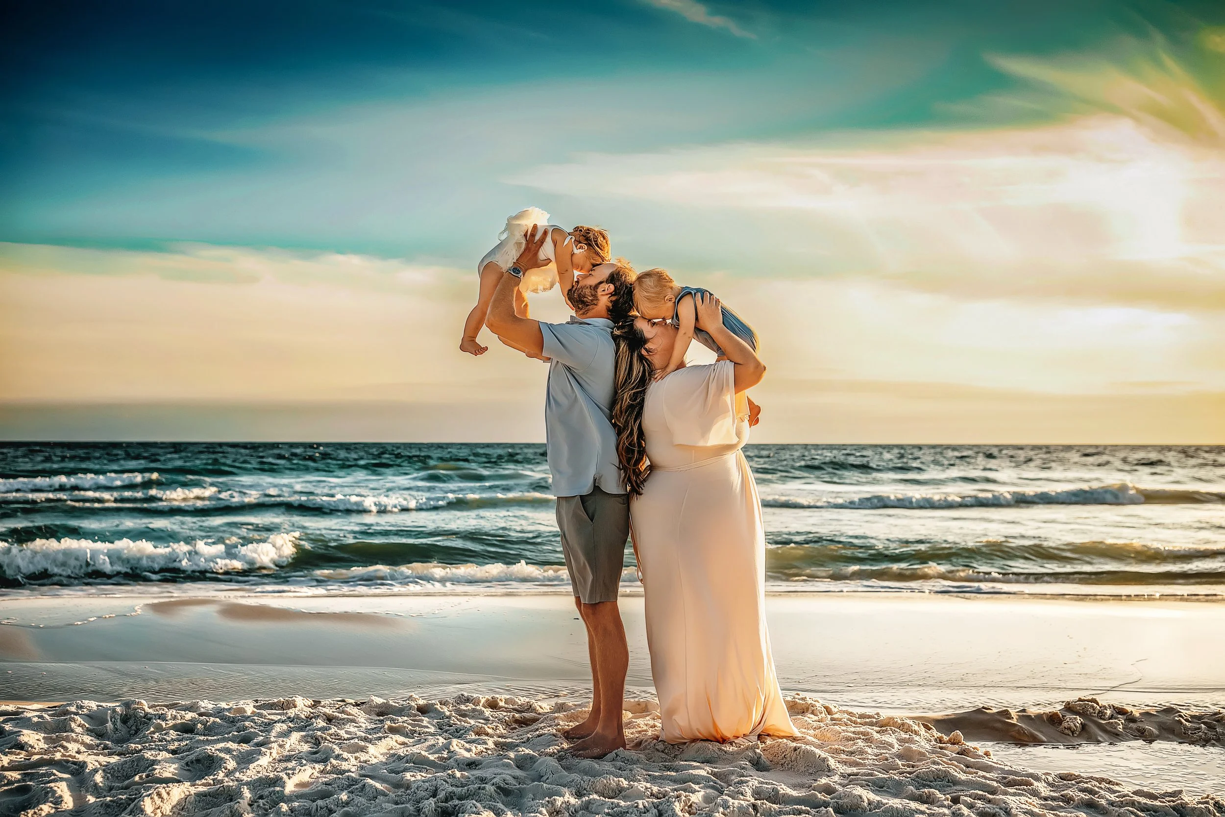 Parents lifting their baby in the air during a sunset family photography session on the beaches of 30A