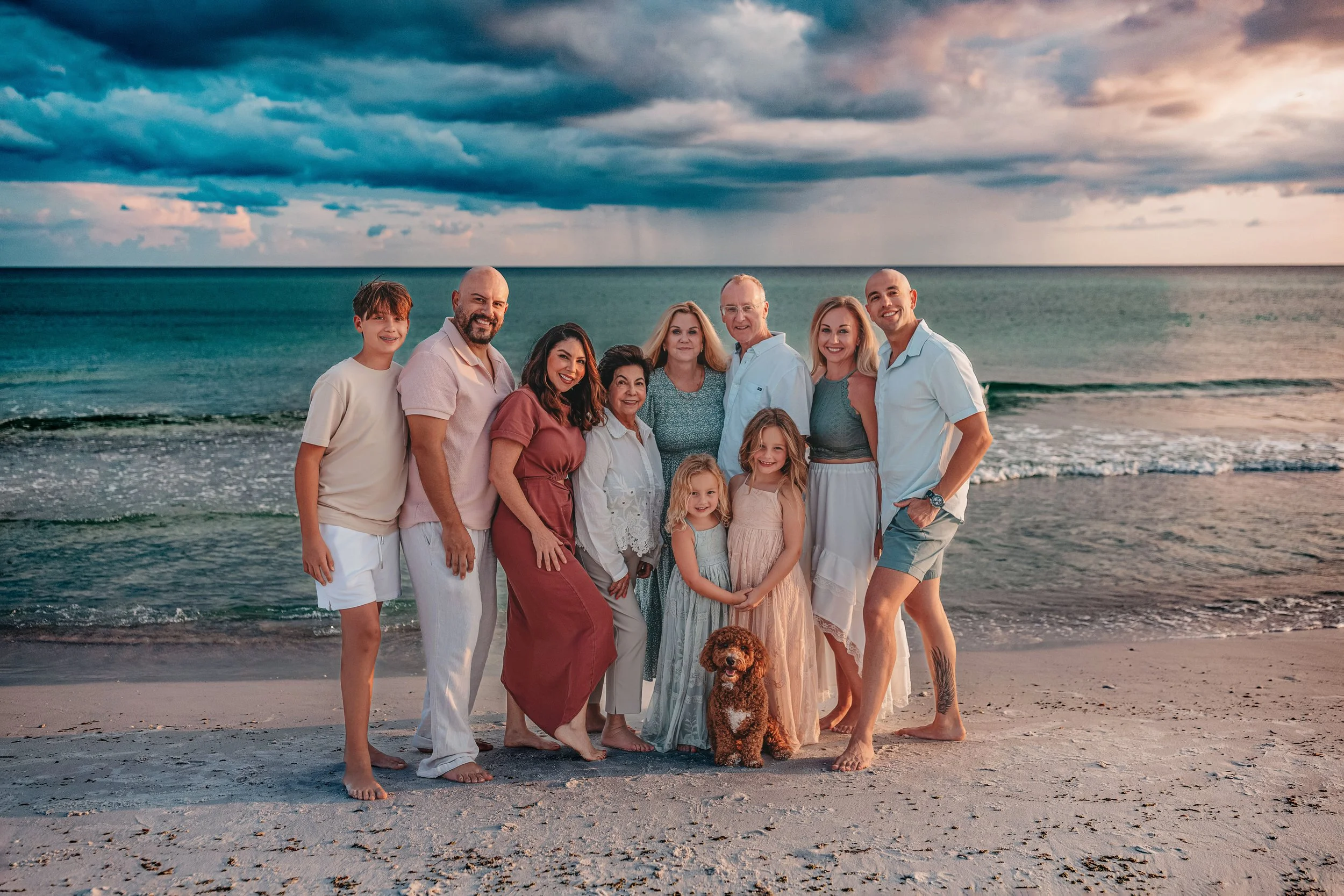 A large multi-generational family group posing on the wide beach at Inlet Beach, Florida.
