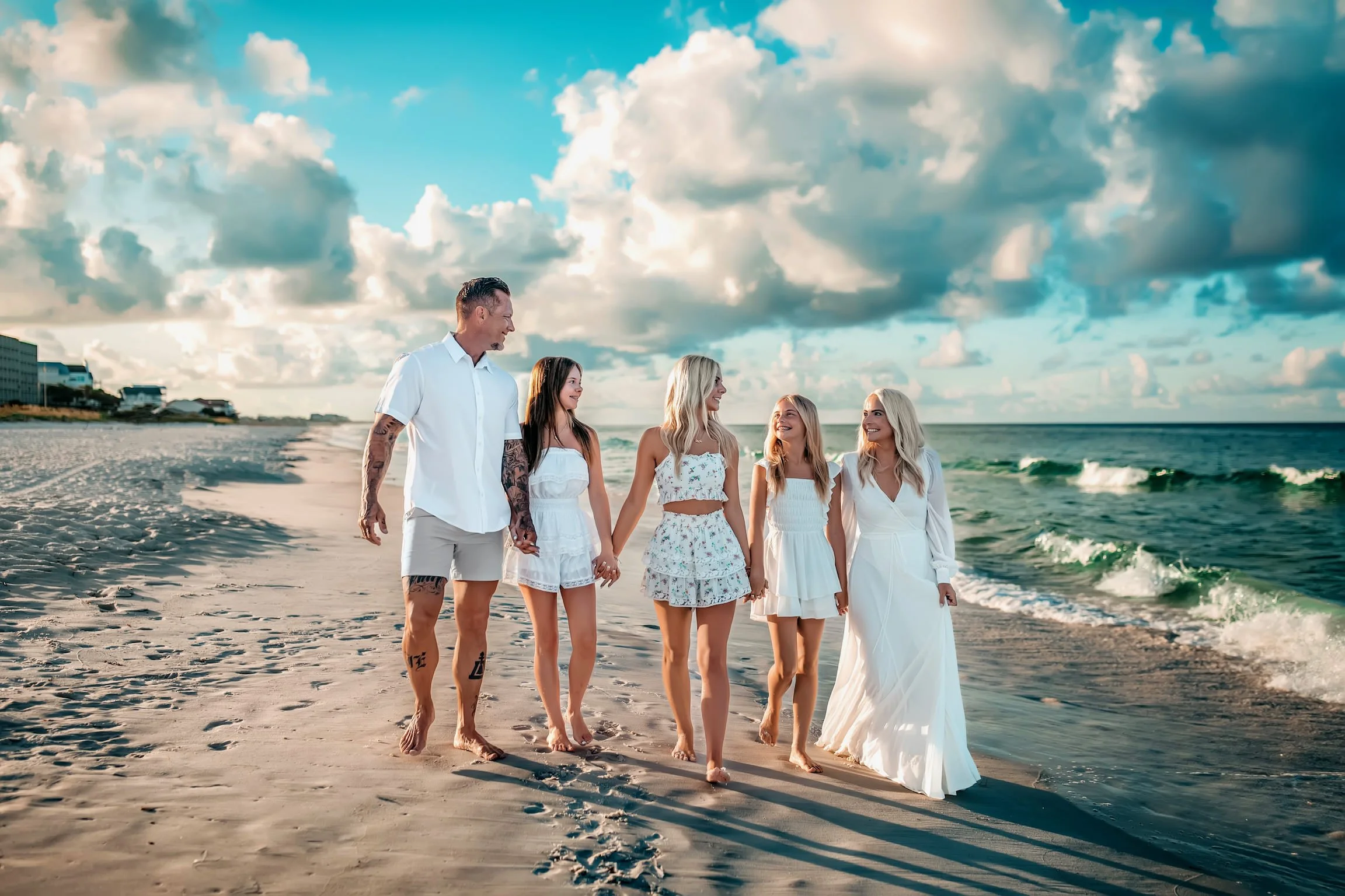 Family of five walking hand in hand during sunrise during their Destin Family Beach Session