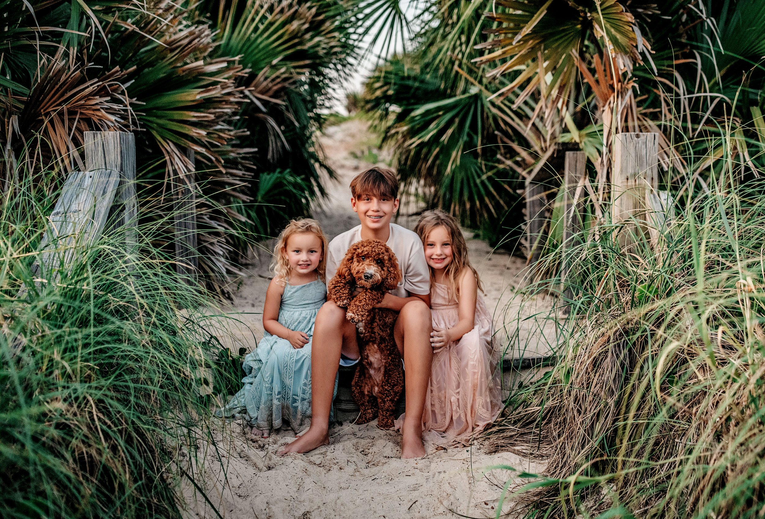 A family with their dog sitting on the boardwalk at Gulf Place in Santa Rosa Beach.