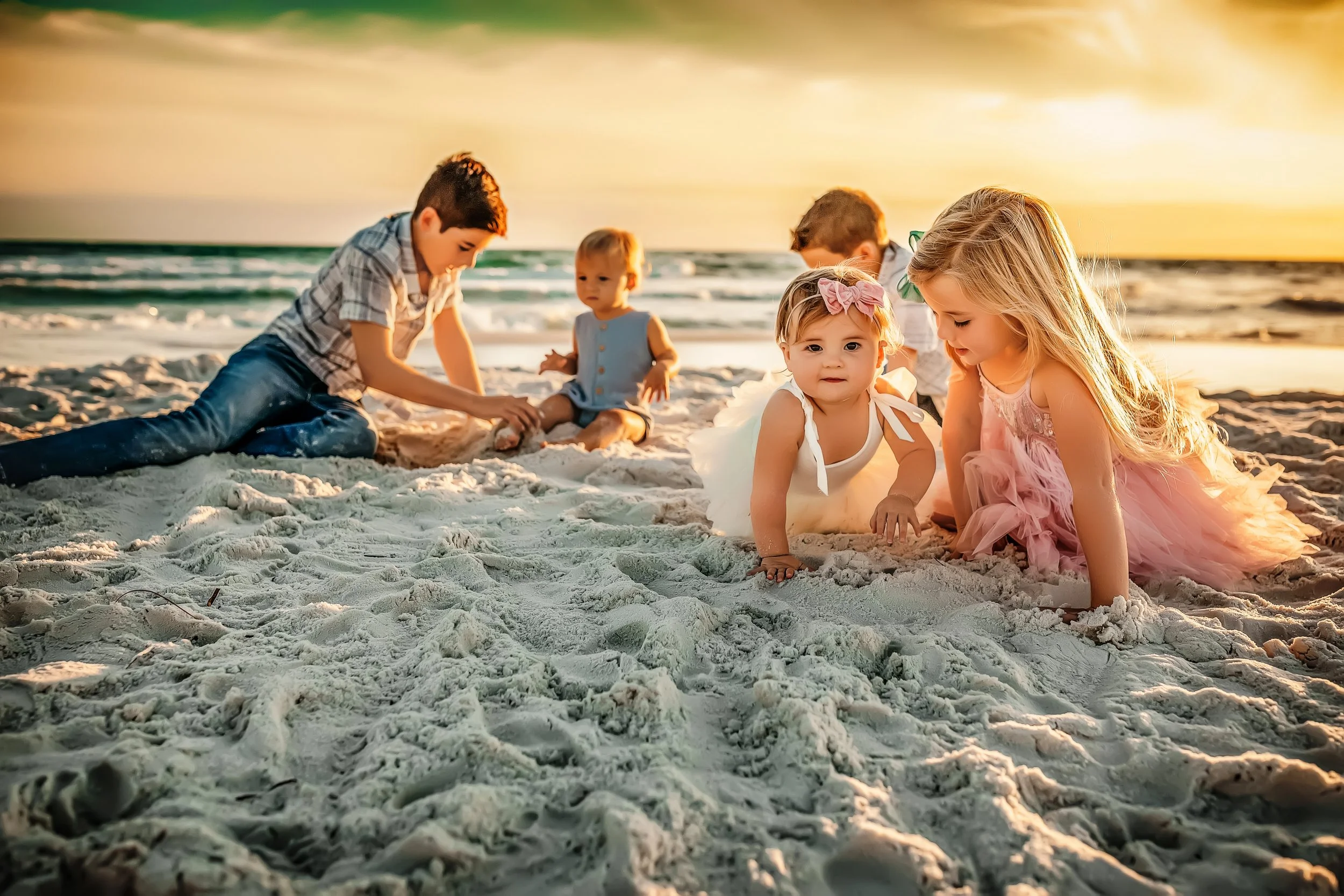 Candid family moment at sunset with children playing along the shoreline during a 30A beach photography session