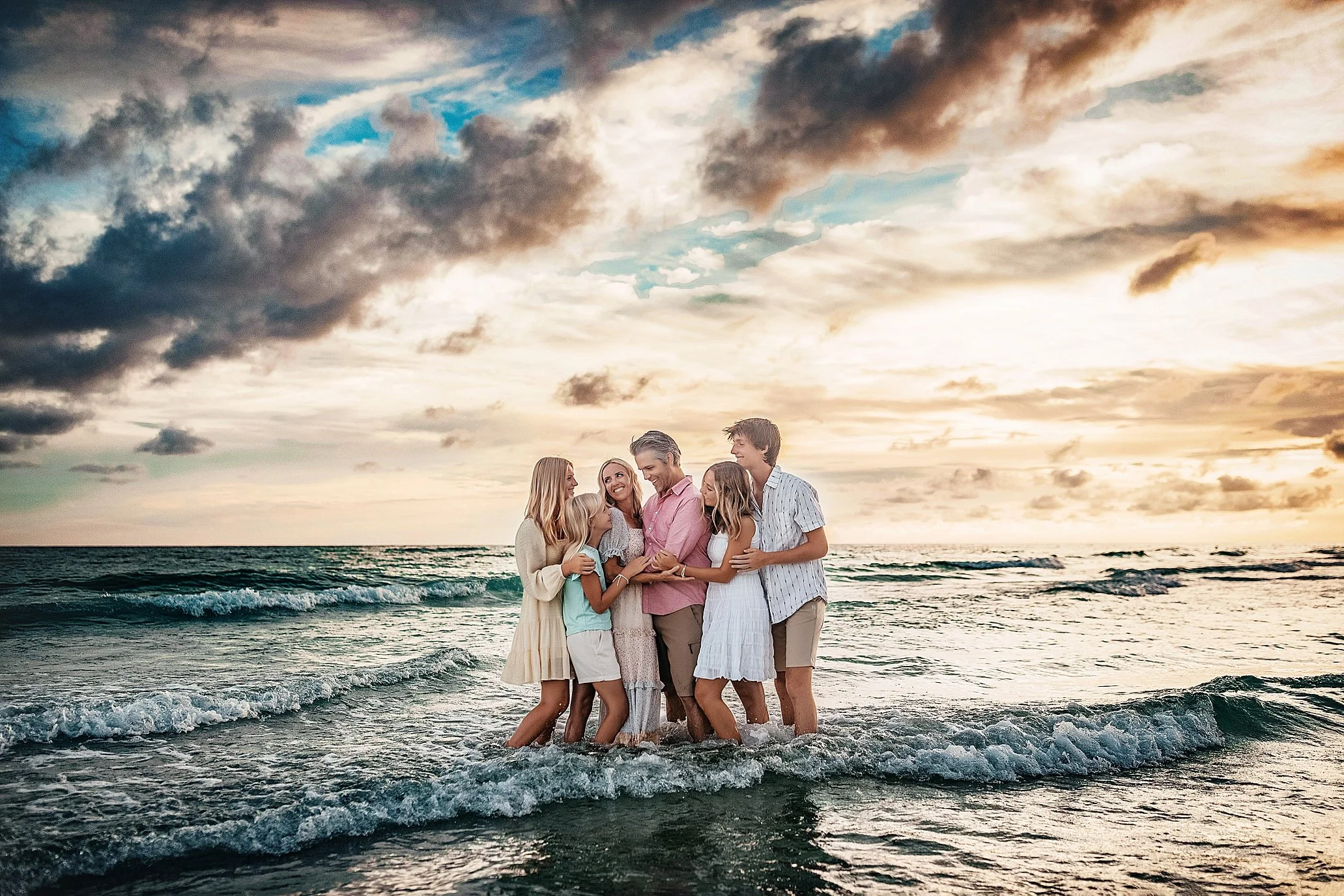 Multigenerational sunset session on 30A photographed in the shoreline with warm golden tones and candid lifestyle movement ideal for extended family vacation portraits across Seaside, WaterSound, and Inlet Beach.