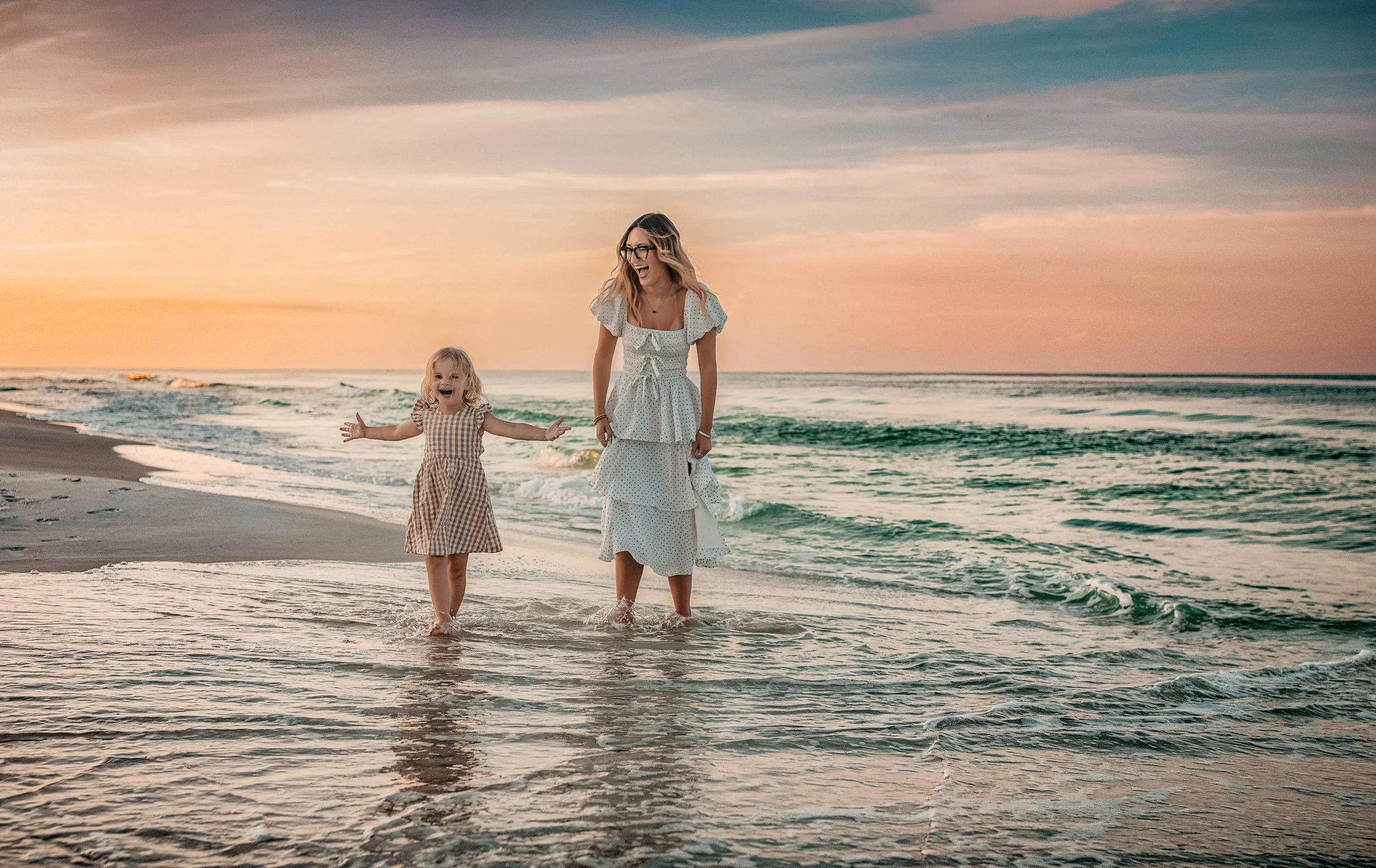 Coastal sibling  session during sunset on 30A with flowing dresses, barefoot ocean movement, and natural lifestyle posing, ideal for feminine editorial family portraits in Rosemary Beach and WaterColor.