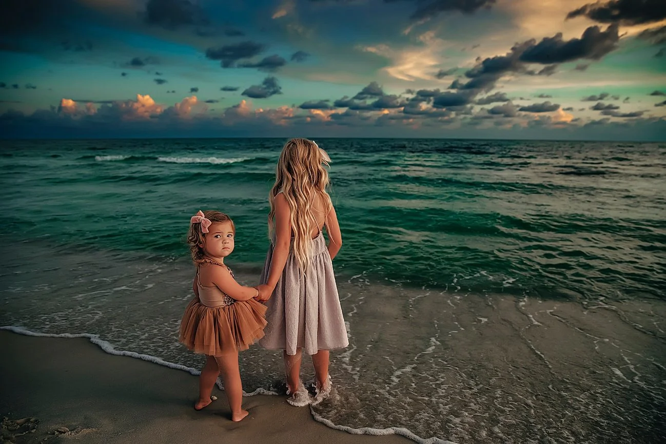 A mother and daughter walking toward the ocean at sunset at the Sandestin Golf and Beach Resort.