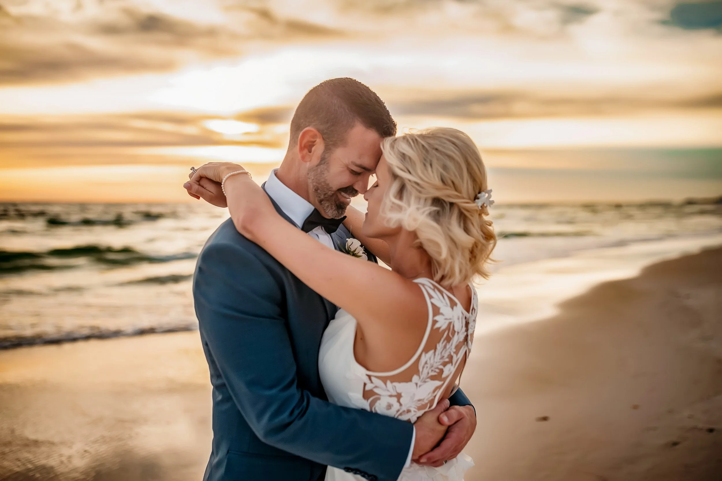 Bride and groom embracing during their high-end wedding on 30A that took place at sunset.