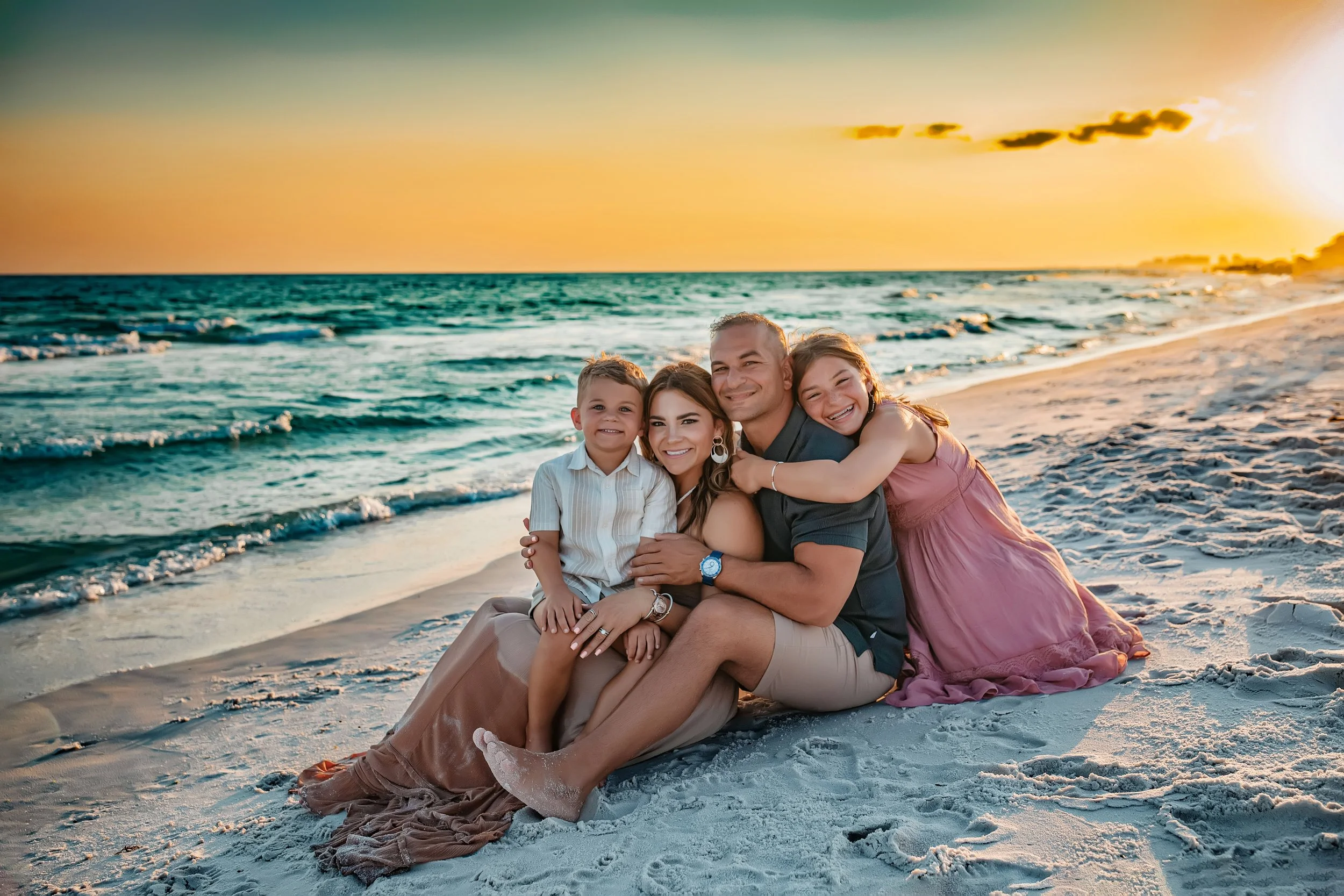 Family of four embracing during their sunset beach session in Santa Rosa Beach, Fl