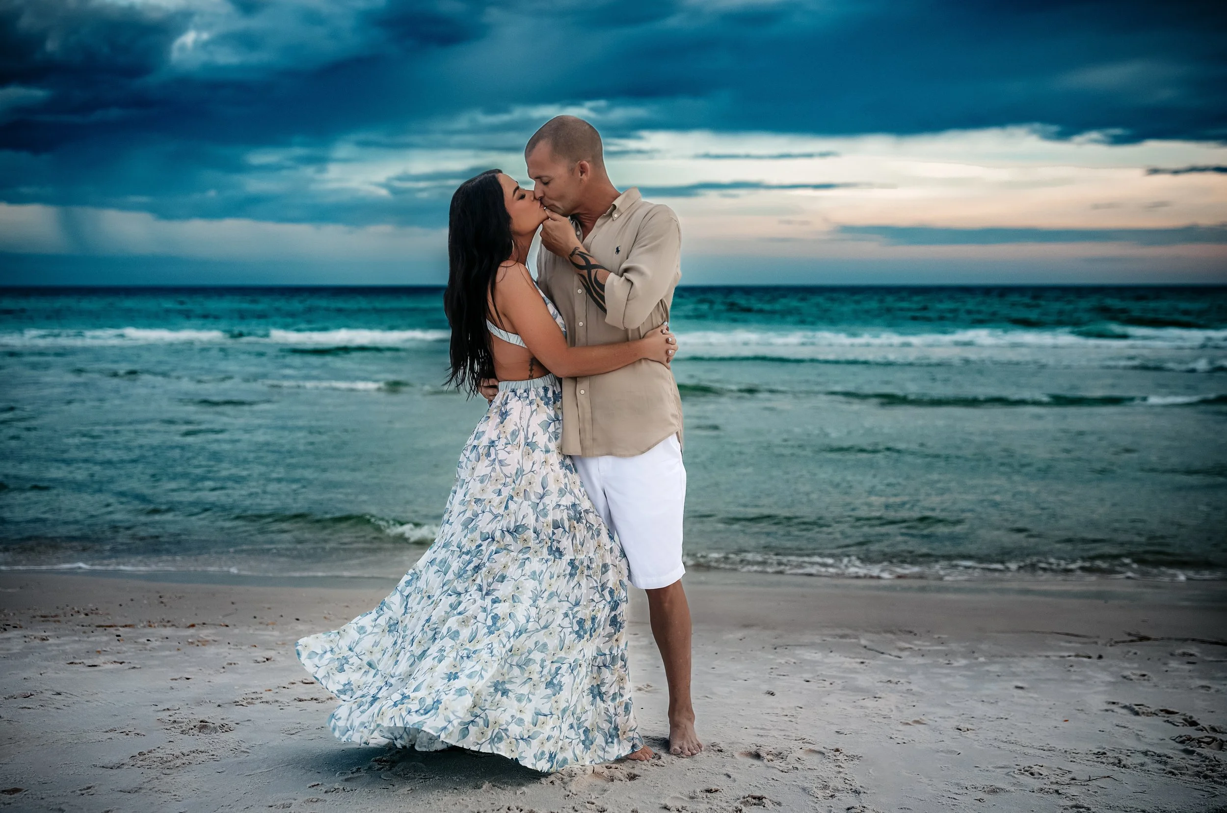 A couple kissing along the Destin shoreline during they engagement session