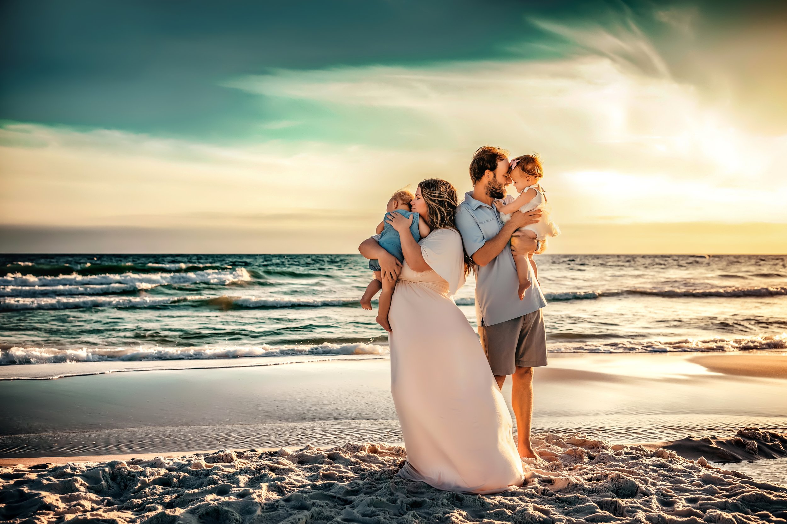 Parents holding their children while standing along the shoreline during a 30A family photo session at sunset
