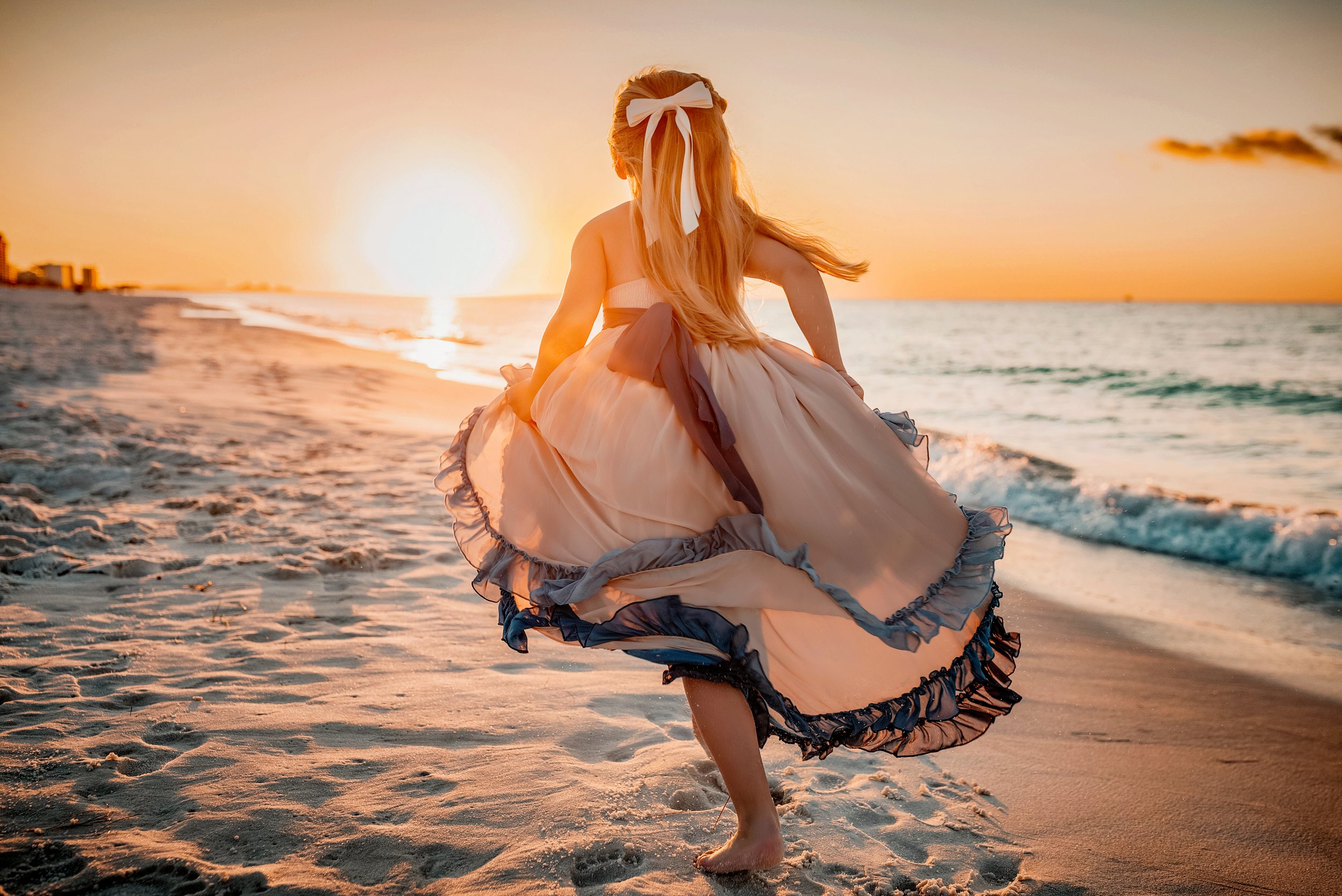Little girl running next to the emerald water on the beaches of 30A at sunrise