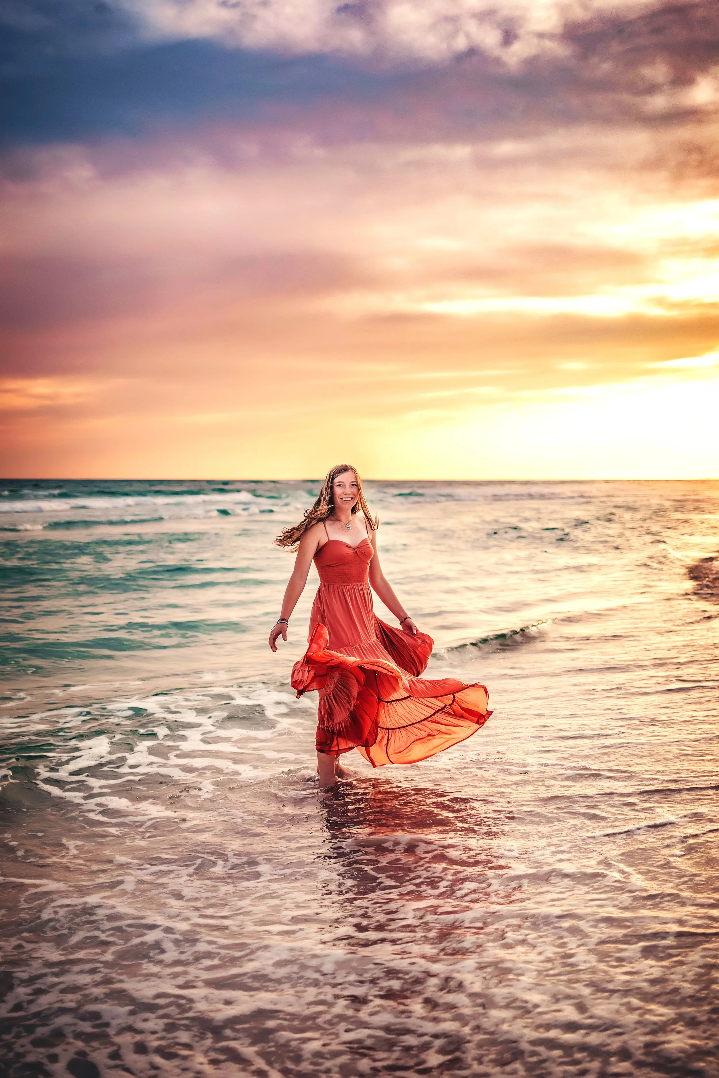 Highschool senior girl twirling during the golden sunset. light during her 30A senior session.