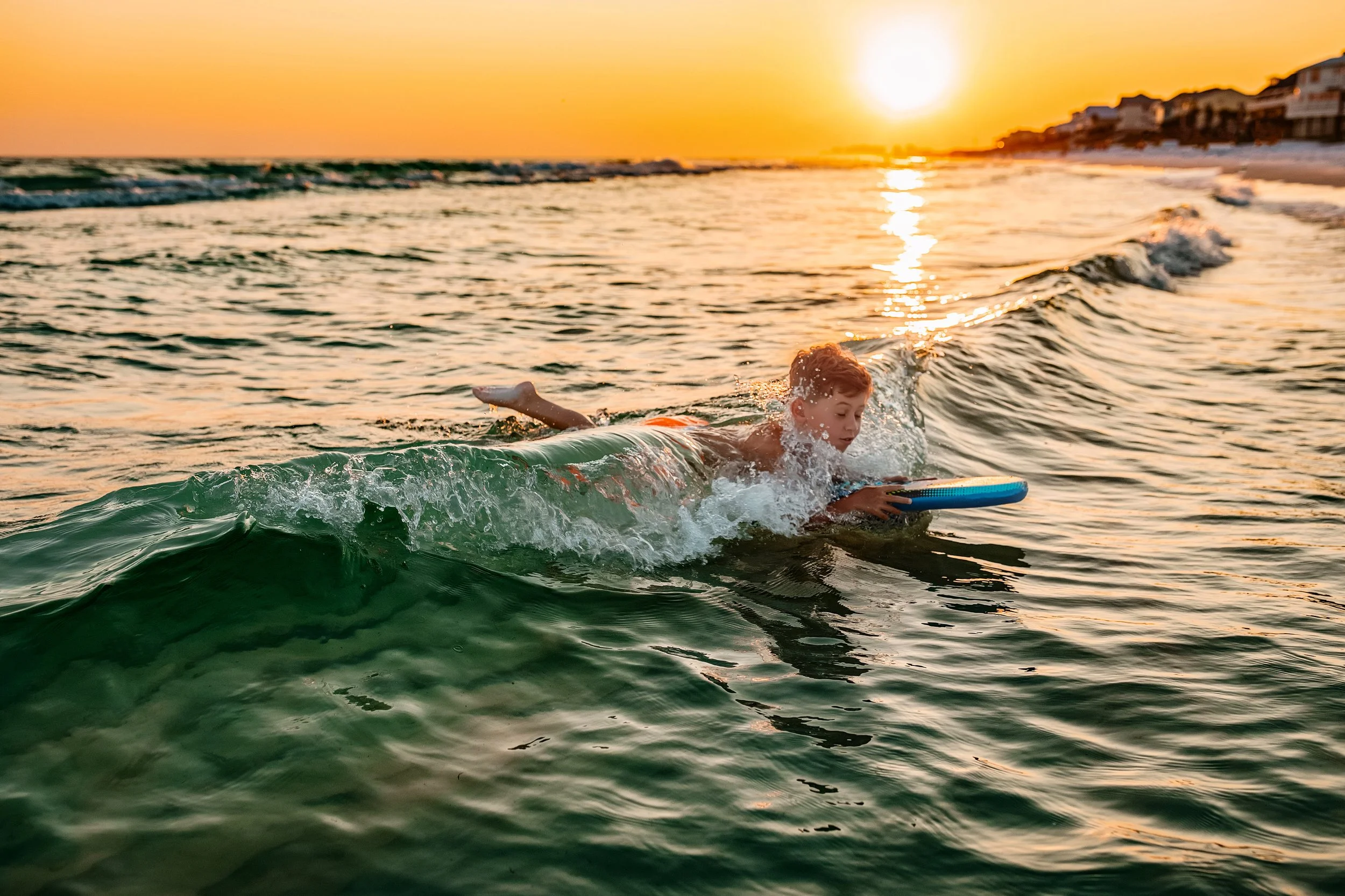 Little boy on a bougie board on the beaches of 30A during family session