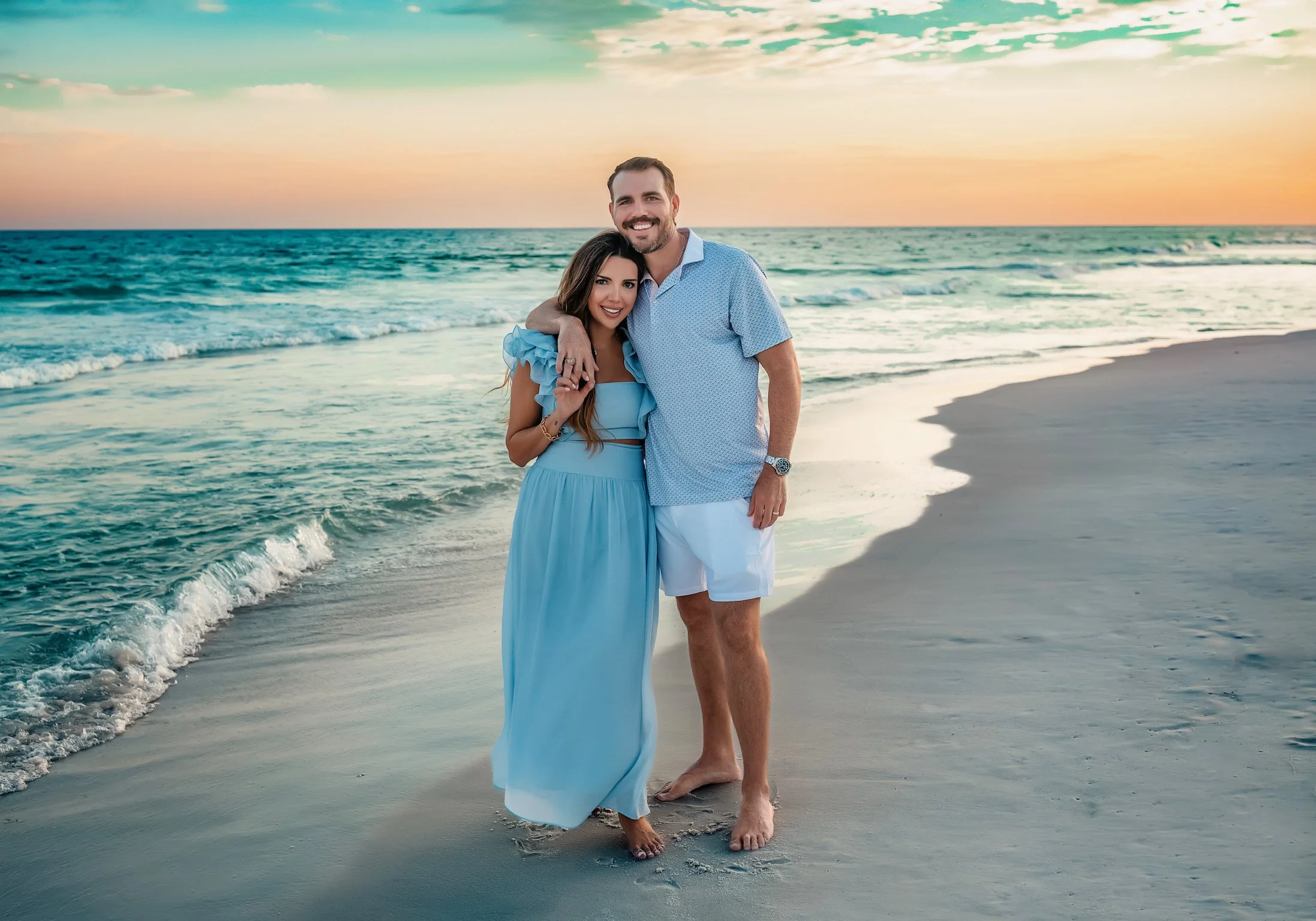 Couple embracing during their Destin beach session near the emerald water
