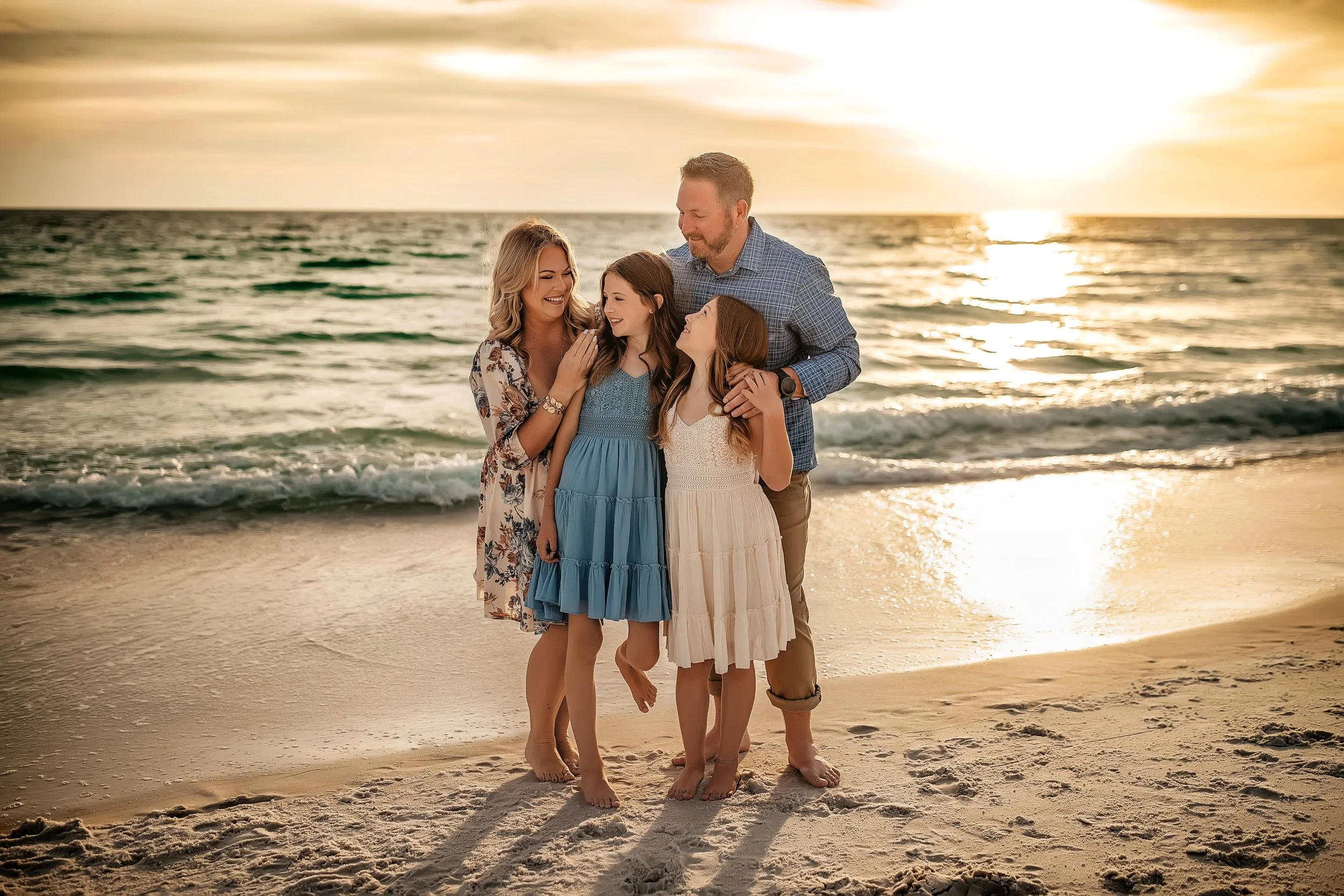 Family of four giggling and smiling during their Destin family beach session