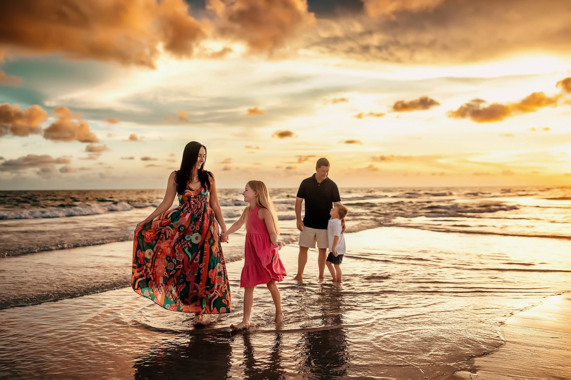 Family of four walking on the Miramar beach during their family sunset session