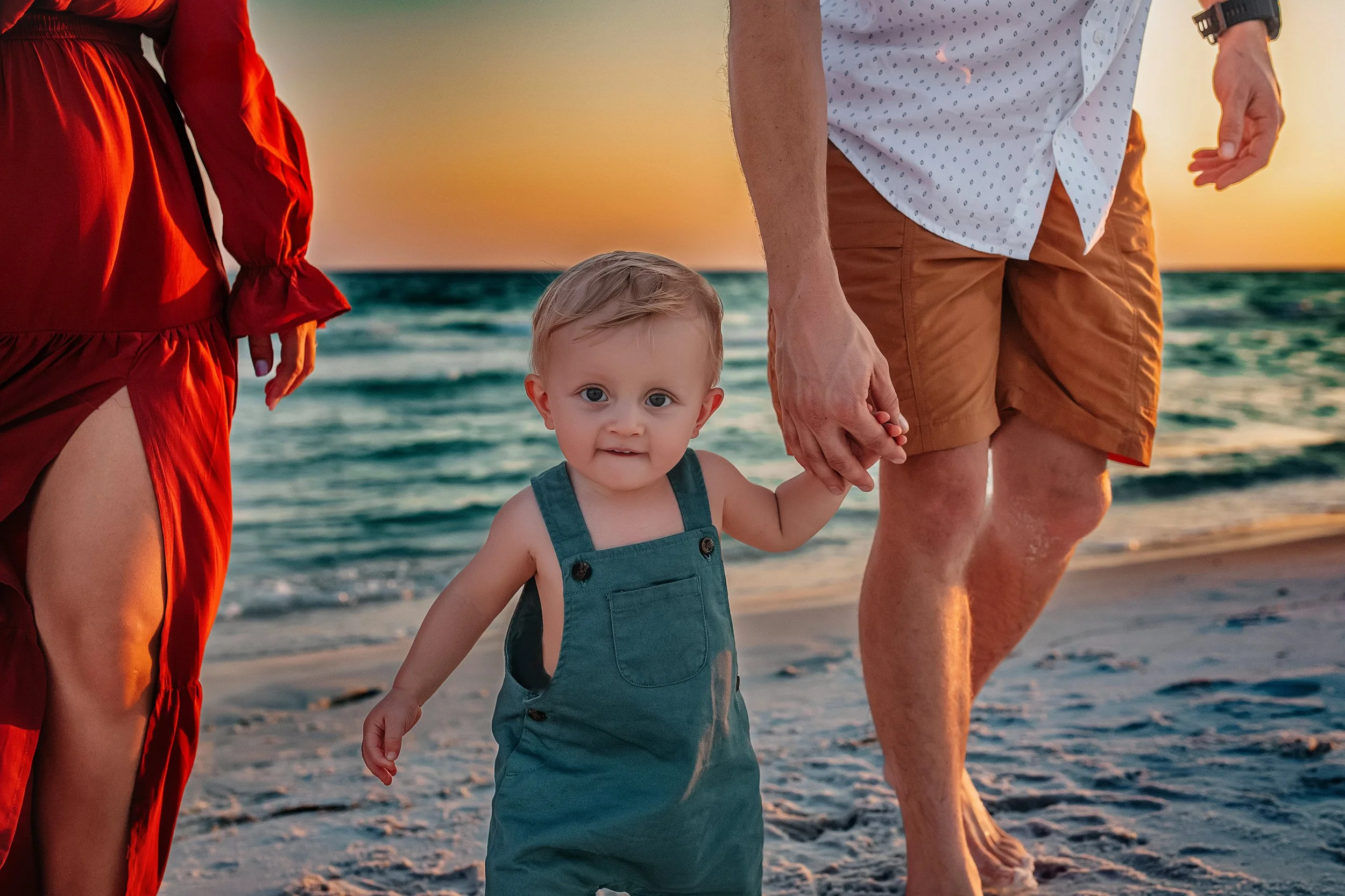 Toddler holding dad's hand on the beach during Inlet Beach family photography session on 30A