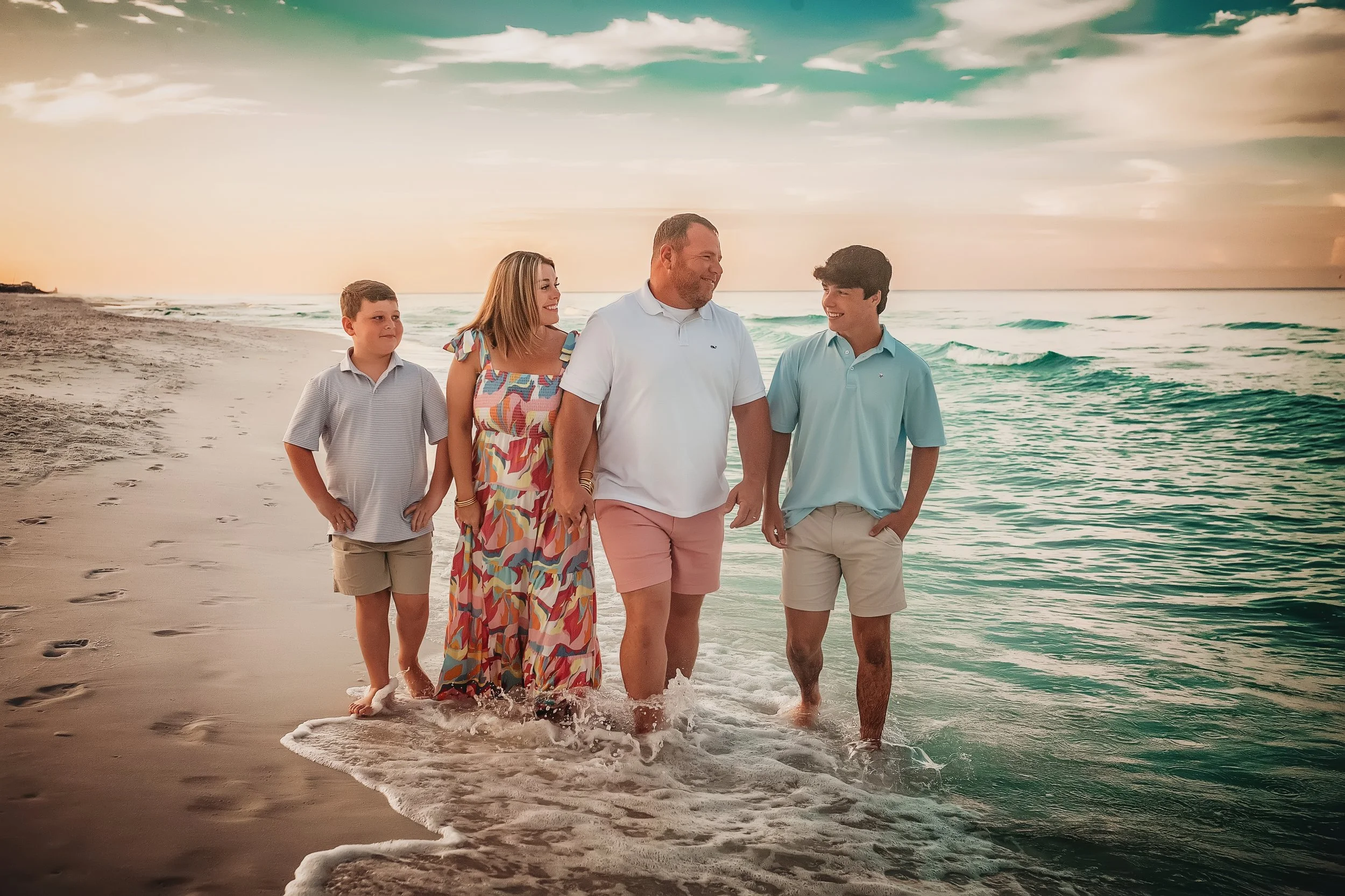 Family walking on the 30A beaches at sunrise along the gulf water