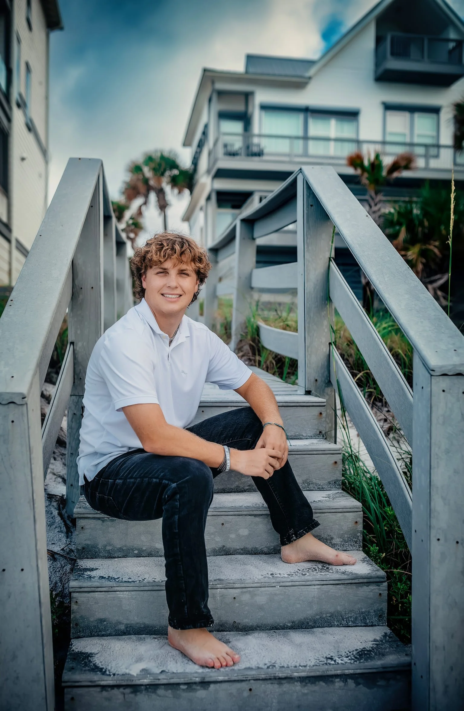 A highshool boy sitting on the steps during his senior session in Miramar