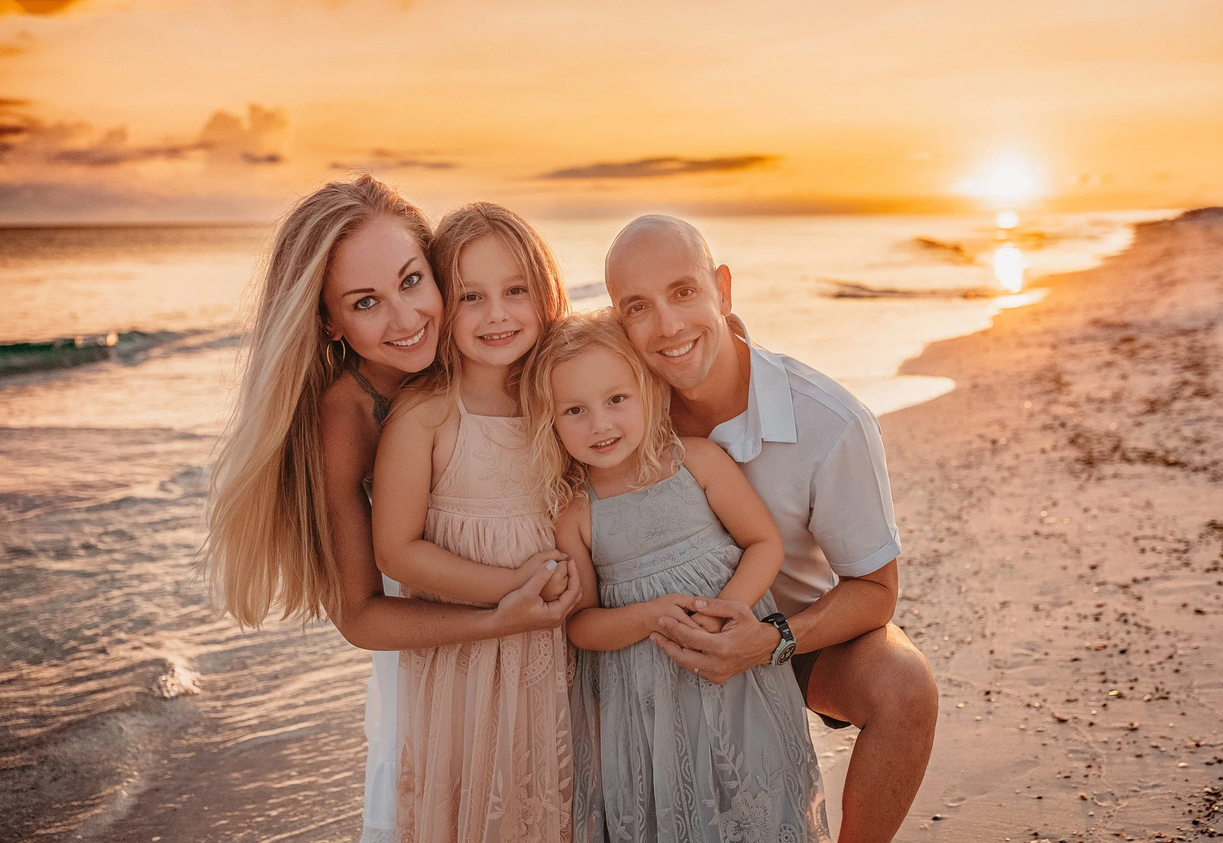 Immediate family of four posing at sunset on Inlet Beach photographed by a 30A family beach photographer