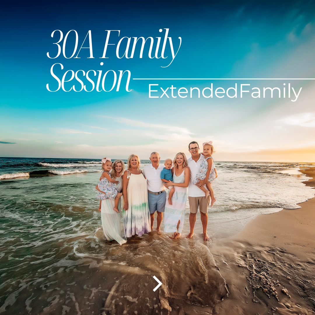 Extended family of eight in coordinating pastel tie-dye and white outfits standing together on the white sand beach at 30A at golden hour sunset, photographed by 30A beach photographer Lisa Marie