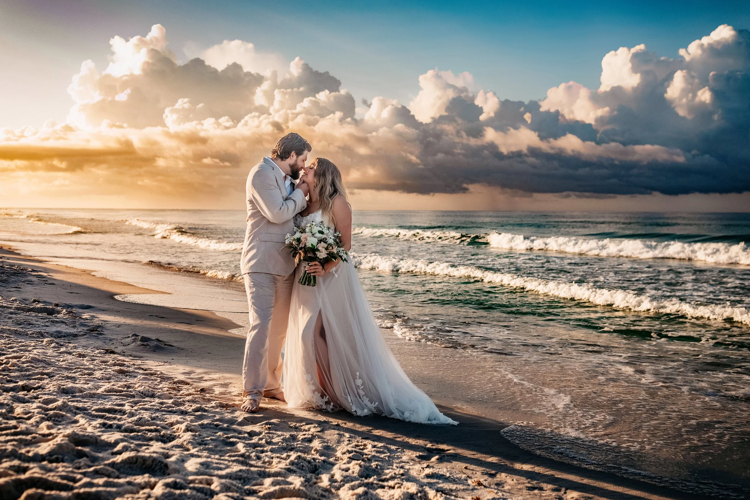 Bride standing alone at sunrise on Destin beach holding bouquet during intimate beach wedding
