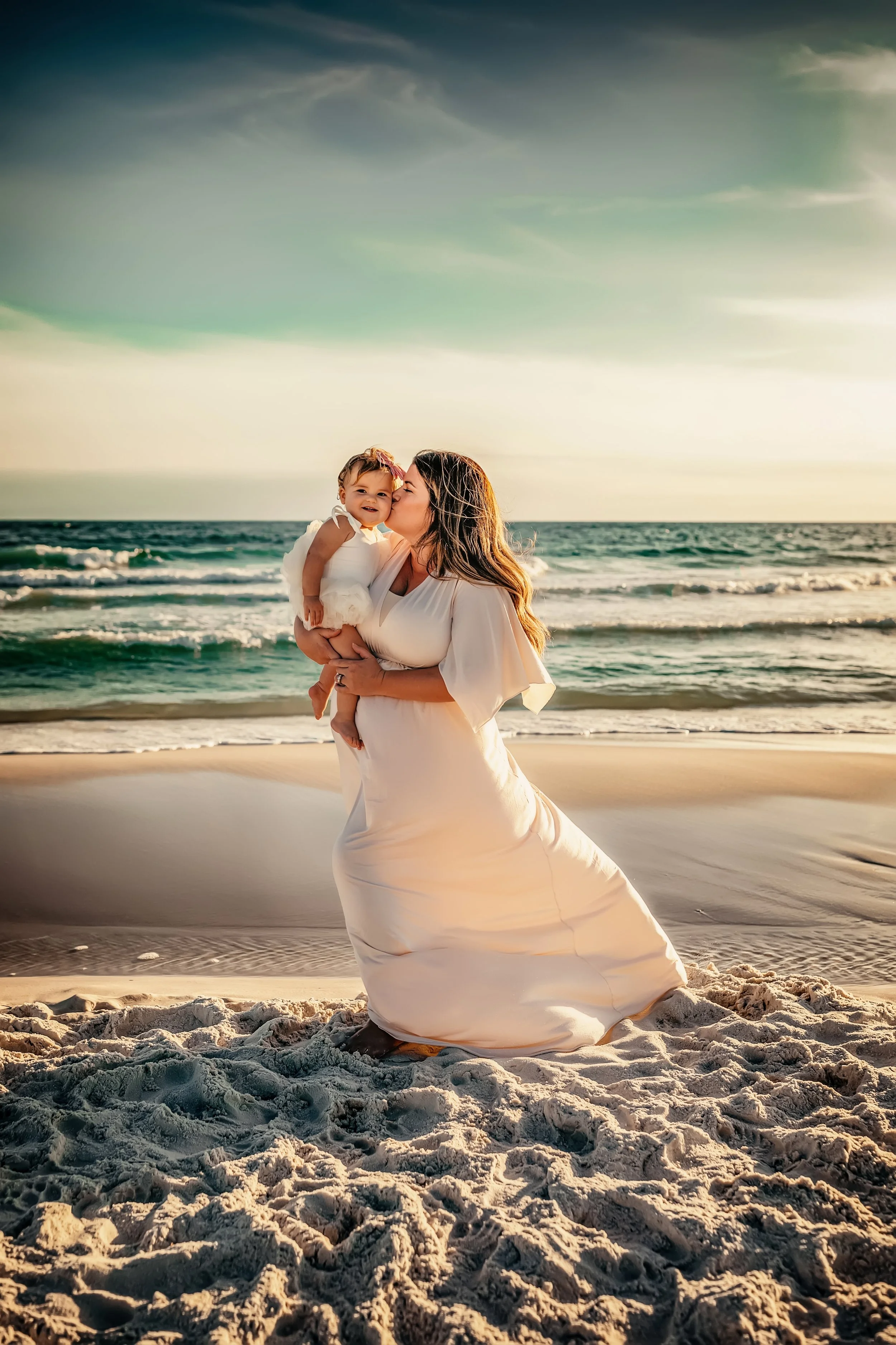 Mother holding her baby on the beach at sunset during a natural family photography session on 30A