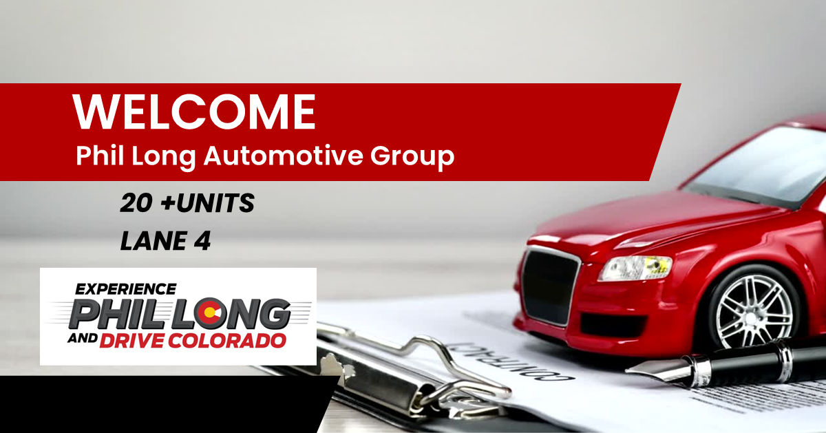 A promotional sign for Phil Long Automotive Group with a red toy car, a pen, and documents.