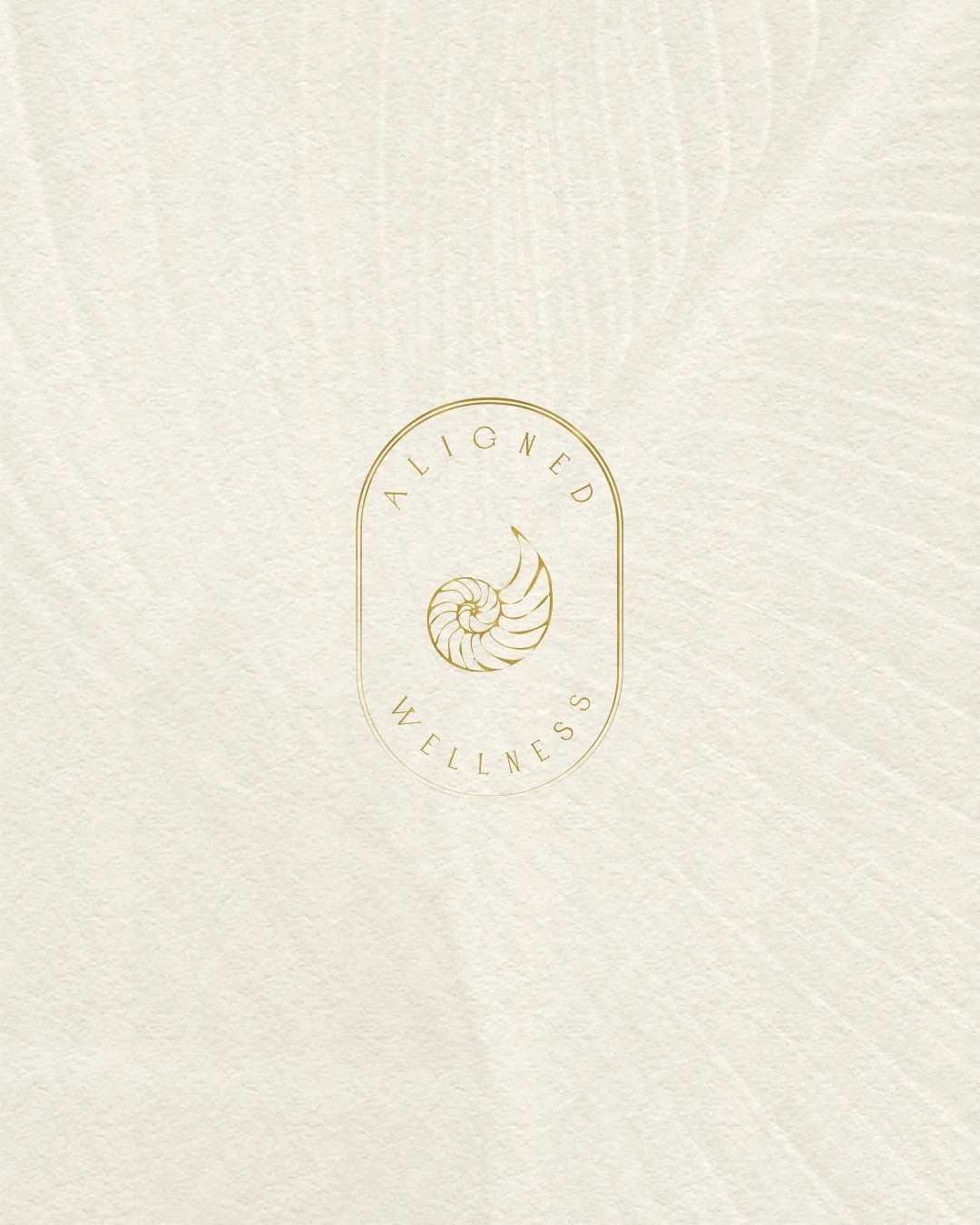 Minimalist logo with a curled shell in the center, surrounded by the words 'ALLIGNED WELLNESS' in gold on a textured off-white background.