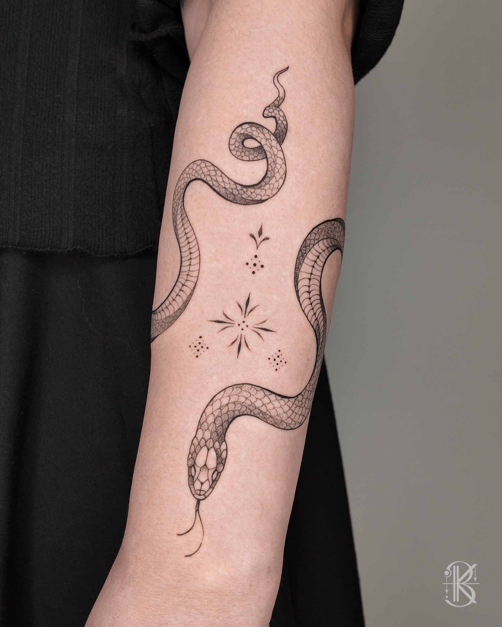 Fine line forearm wrap-around snake tattoo by Karen Byers Ink, ornamental and black & grey tattoo artist based in Birmingham, UK – Featuring intricate ornamental details in an elegant and modern style.