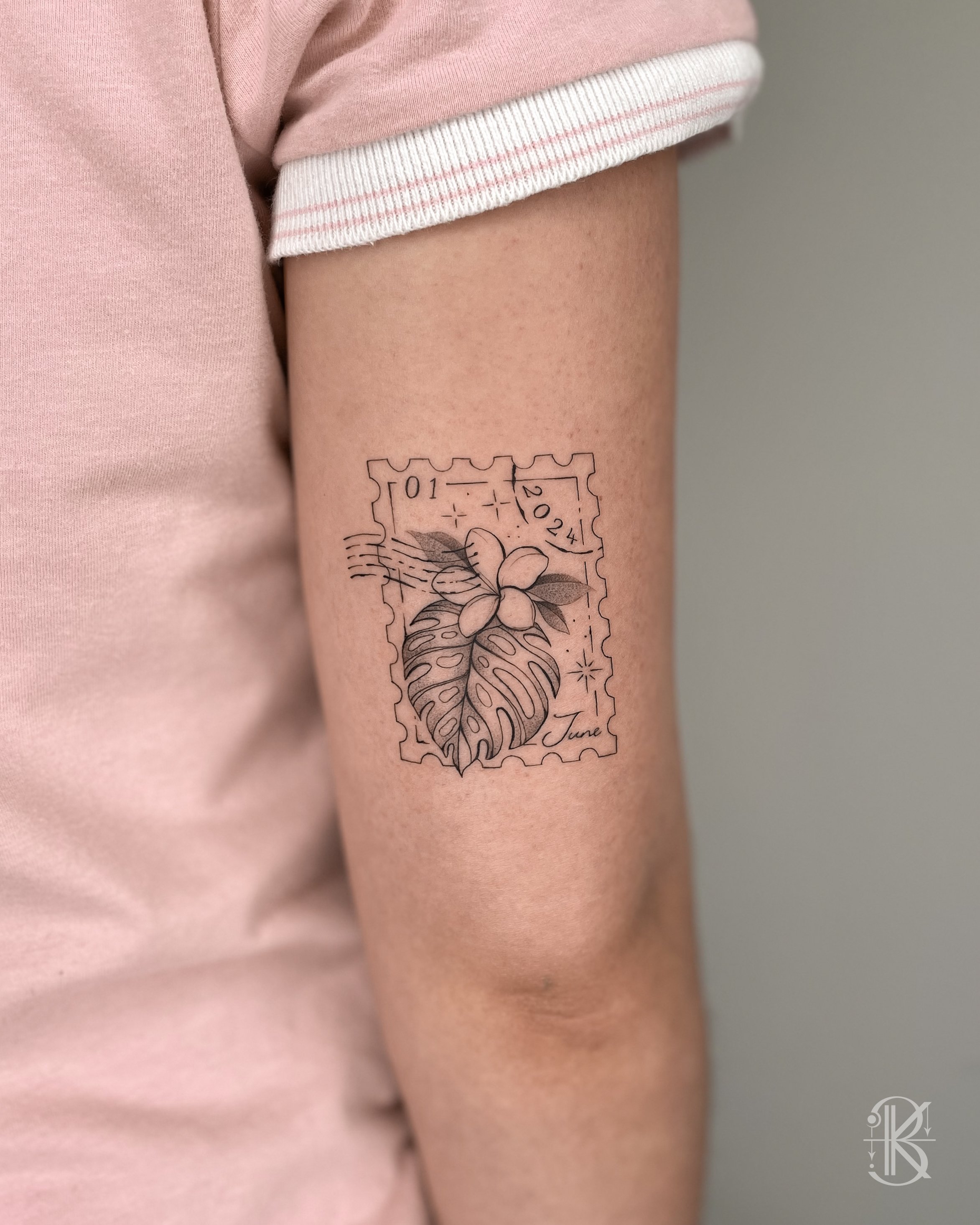 Fine line floral & botanical stamp tattoo above the elbow by Karen Byers Ink, ornamental and black & grey tattoo artist based in Birmingham, UK – Featuring a monstera leaf and frangipani flower.