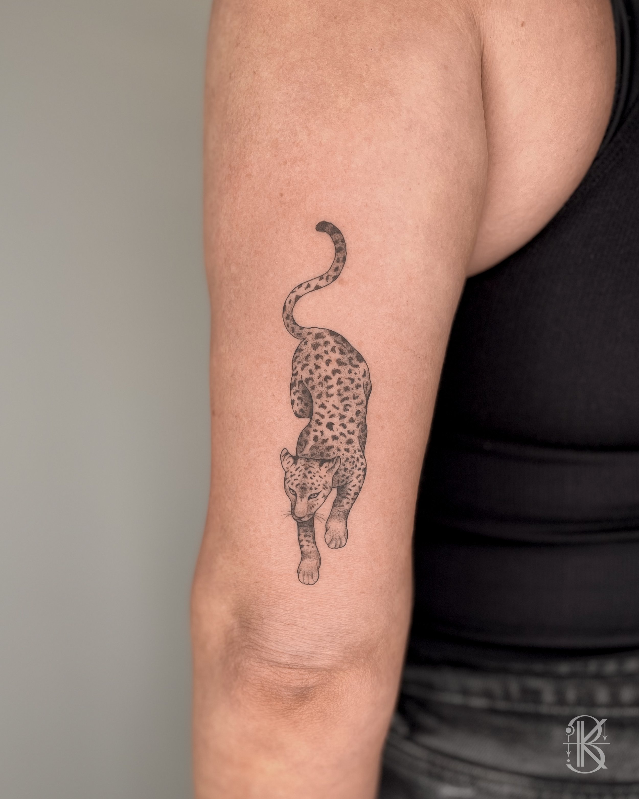 Elegant fine line leopard tattoo by Karen Byers Ink, ornamental and black & grey tattoo artist based in Birmingham, UK – Featuring minimal yet realistic details.