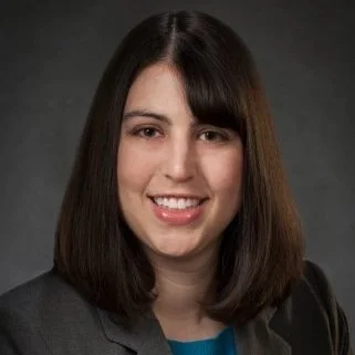 A dark haired white woman smiling