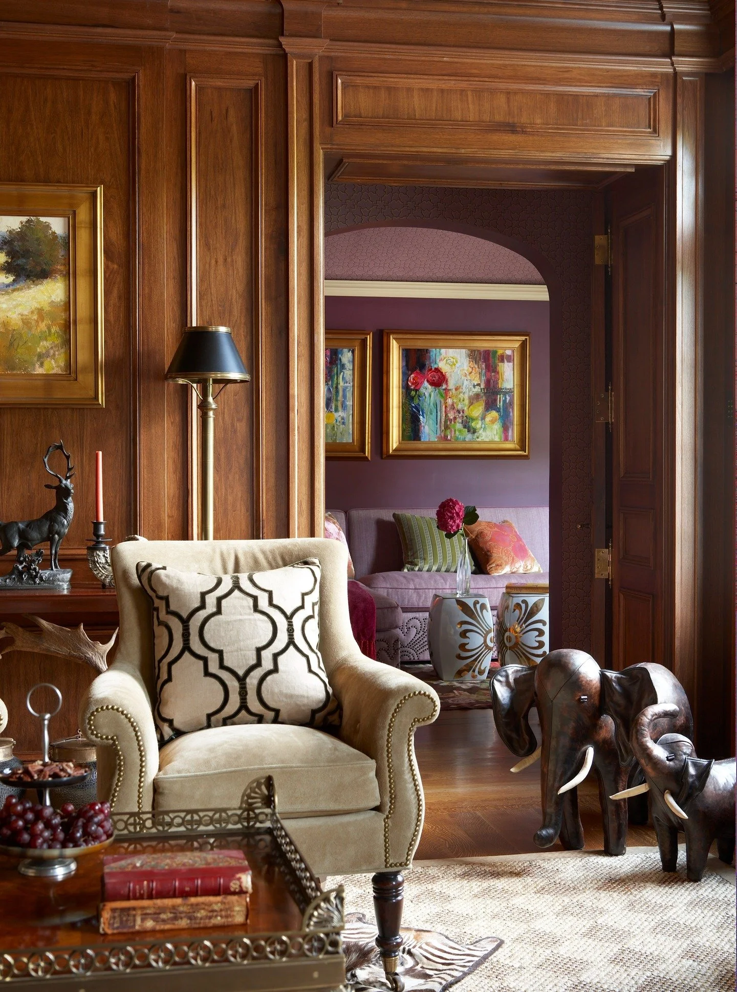 We designed this room to feel calm, grounded, and lived-in. The wood paneling brings warmth and structure, while the furniture and art were chosen to feel natural in the space. Beyond, the dark purple room introduces a subtle shift in tone, adding a 