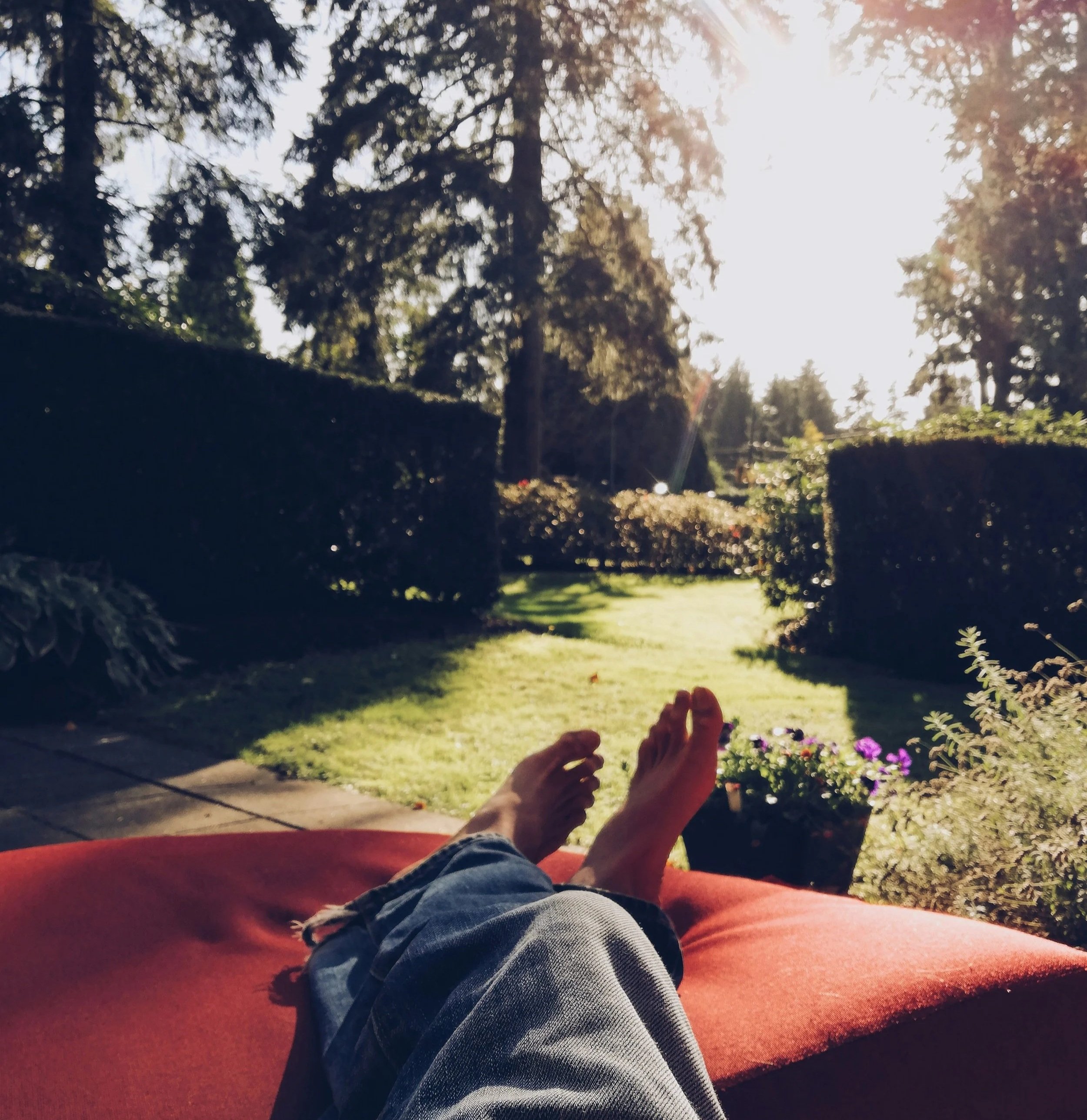 feet propped up on lounge chair in backyard