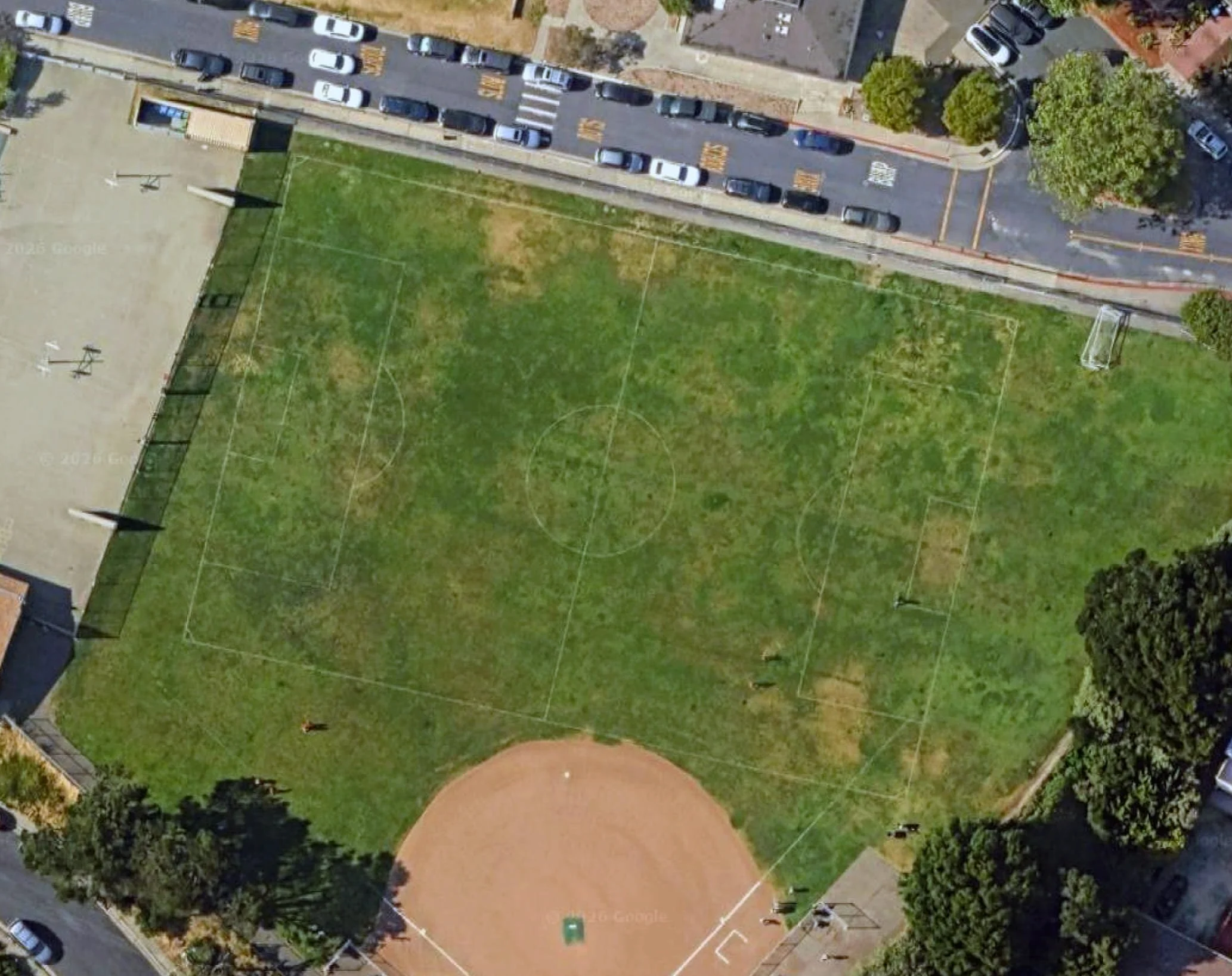 Aerial view of the Canyon Trail Park soccer field in El Cerrito, CA, featuring open grass areas lined for soccer and surrounded by neighborhood streets and trees.