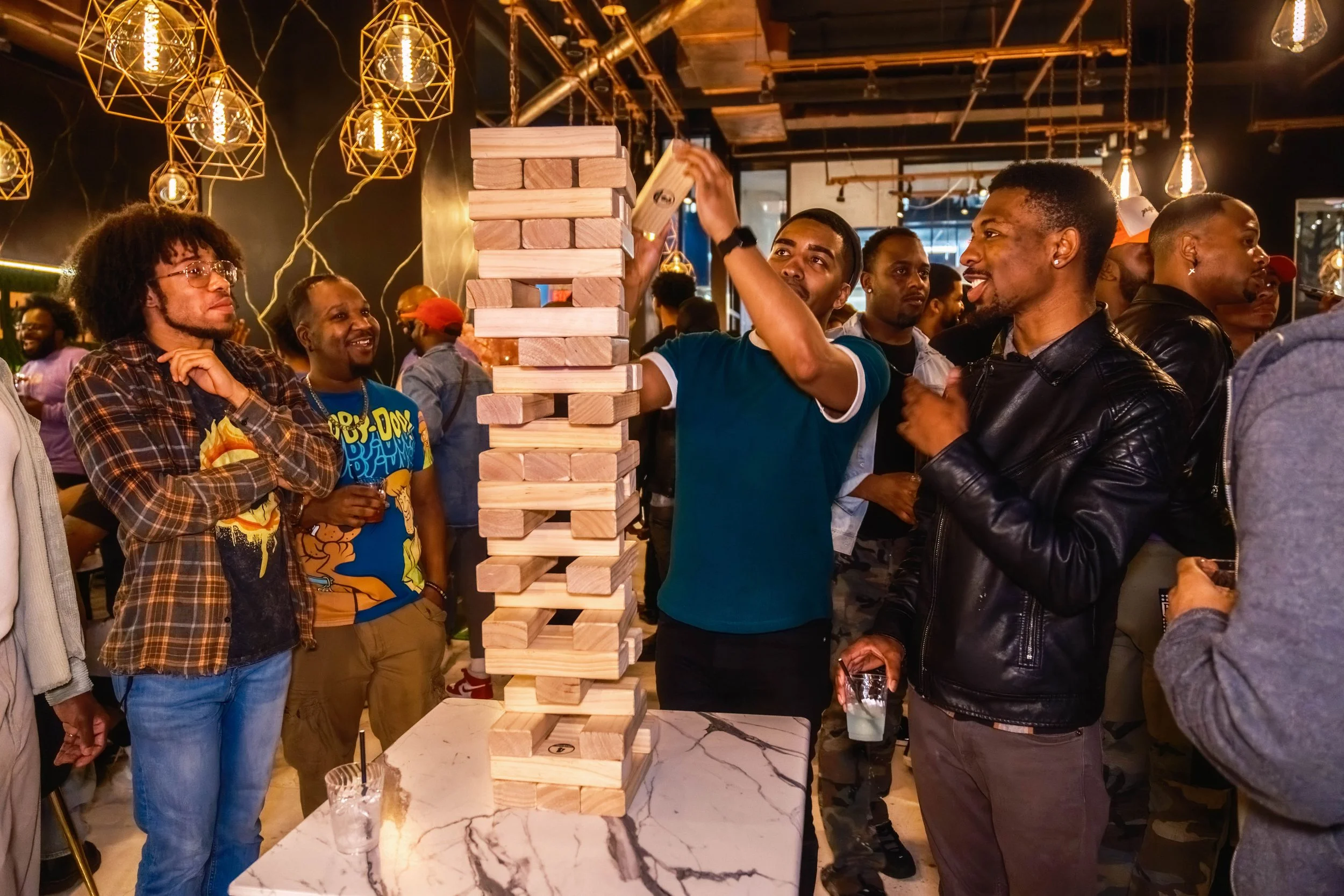 A photo of happy people playing an oversized Jenga game at Game Night DC hosted by Deviant Society.