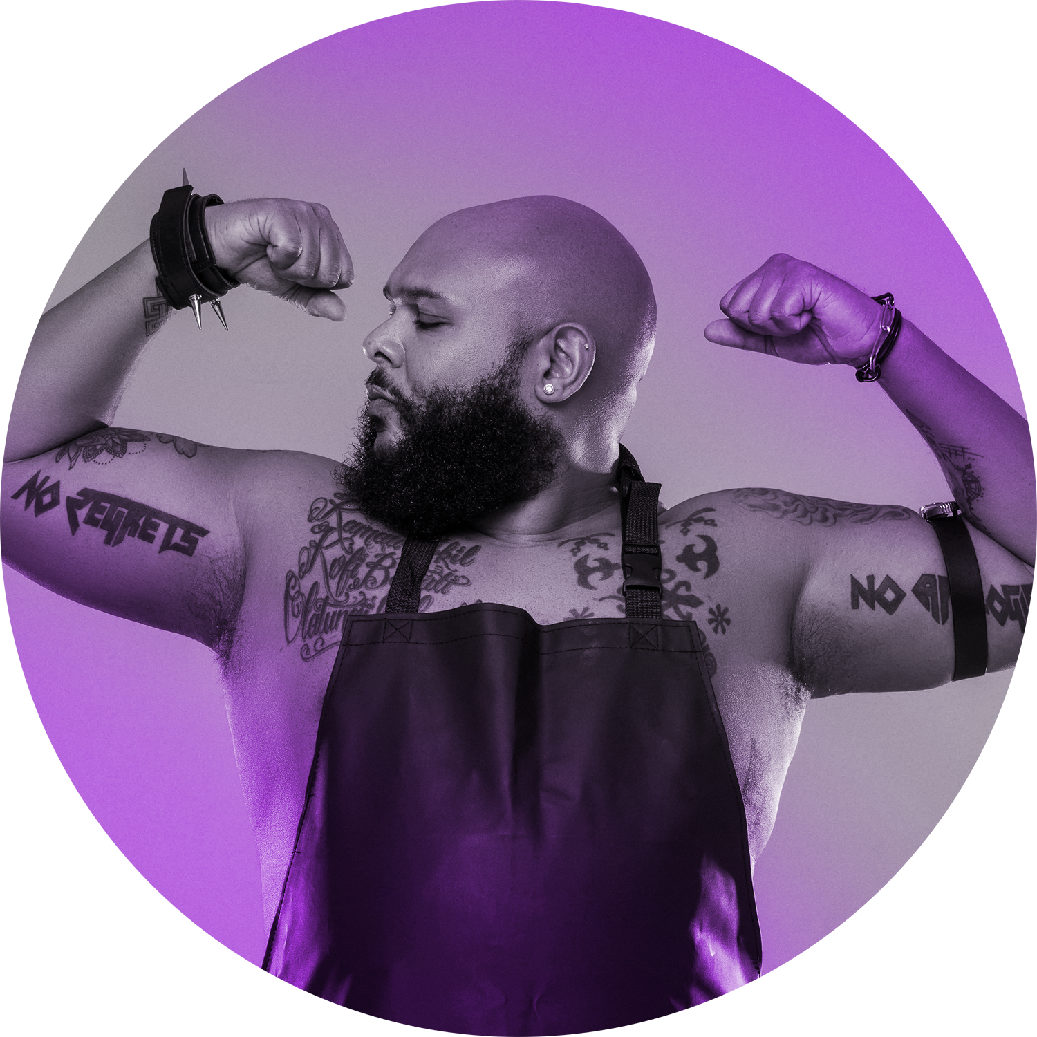 A curvy black man flexing his arms in strength, his tattoos showing on his arms & chest, wearing only a black apron. He's bald & has a luscious beard.