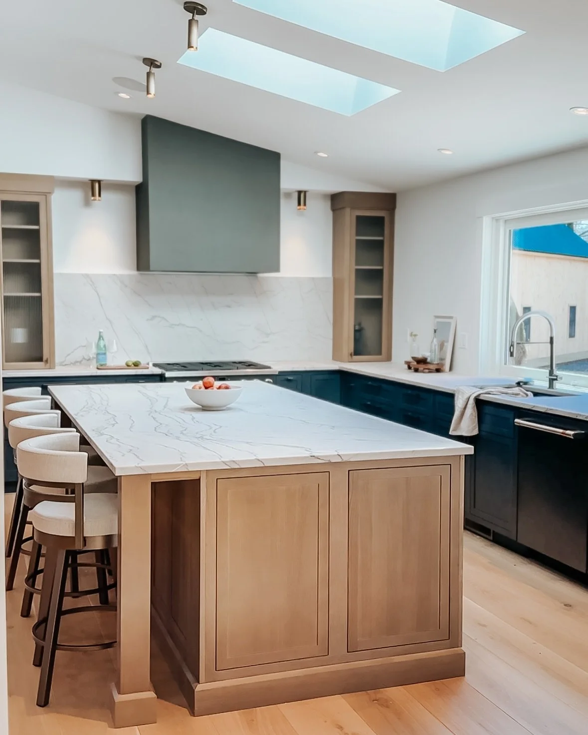 Coastal calm meets modern edge in this sun-drenched oceanside kitchen.

White oak, deep navy, and natural stone come together for a space that feels grounded, fresh, and endlessly livable.
Brass details and skylit moments? Just the cherry on top.

#O