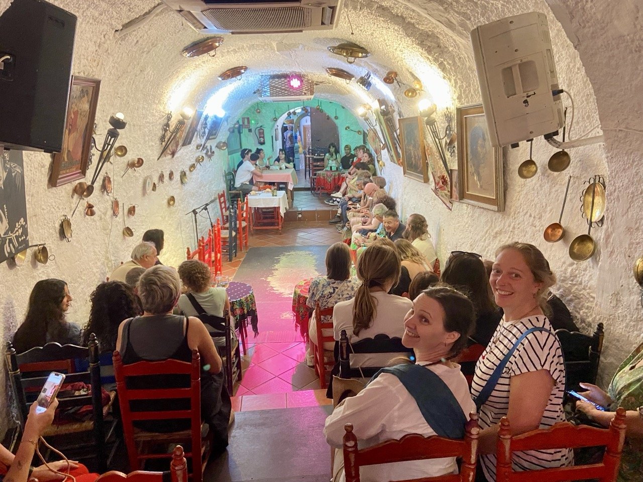 A lively Flamenco performance in a traditional gypsy cave in Granada, Spain, featuring passionate dancers, a guitarist, and vibrant costumes, showcasing the rich cultural heritage of Andalusia.