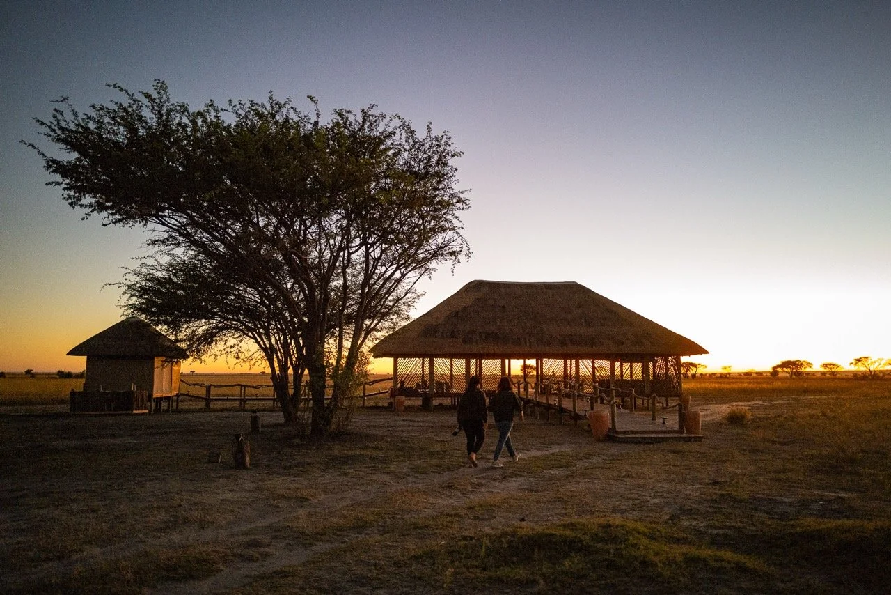 Sunset at Munga Plains yoga safari camp, with a guest looking out across the Botswana landscape in Chobe National Park