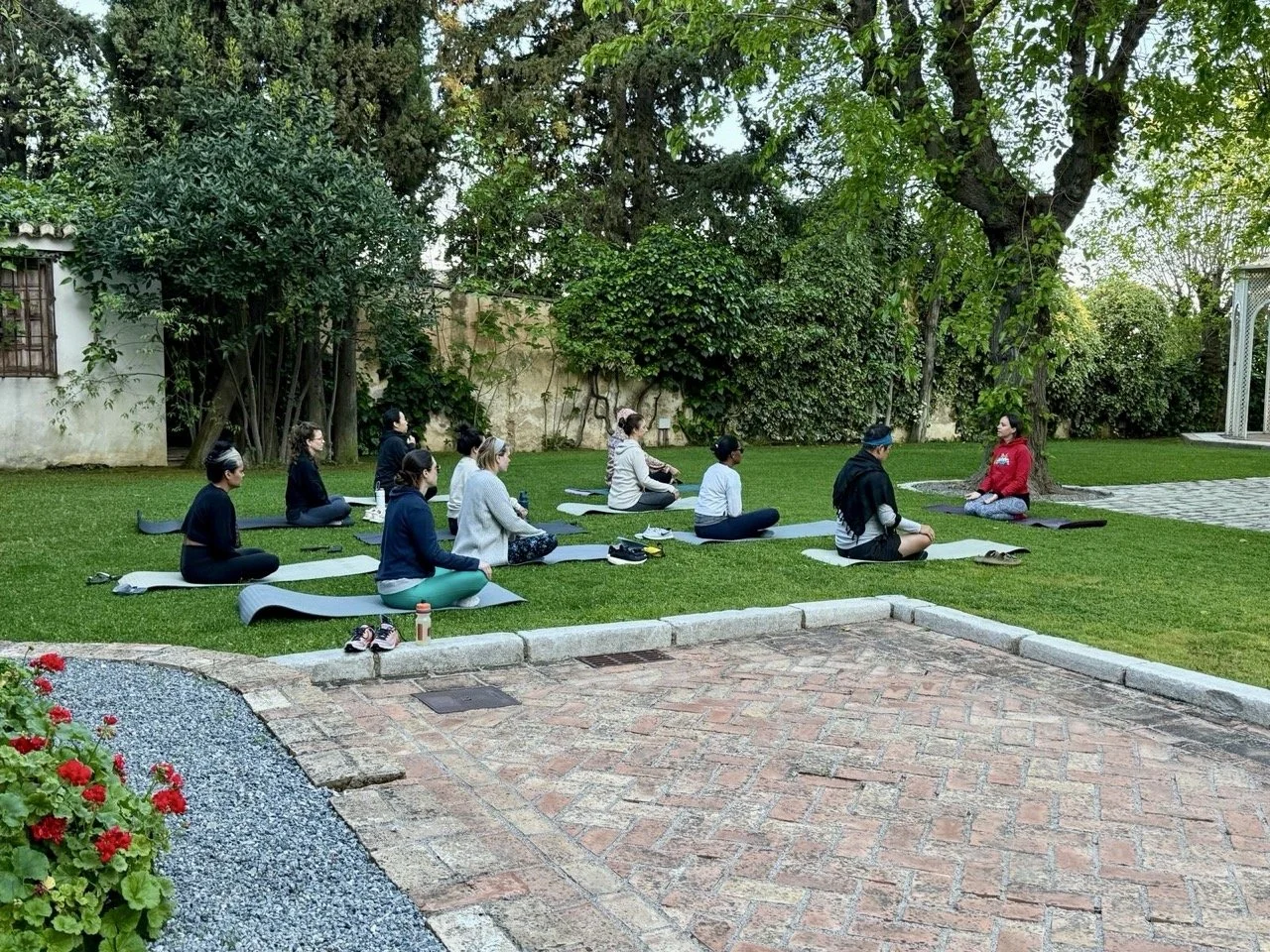A joyful group of retreat participants practicing yoga poses together, capturing the spirit of connection and wellness during the retreat in Granada, Spain.