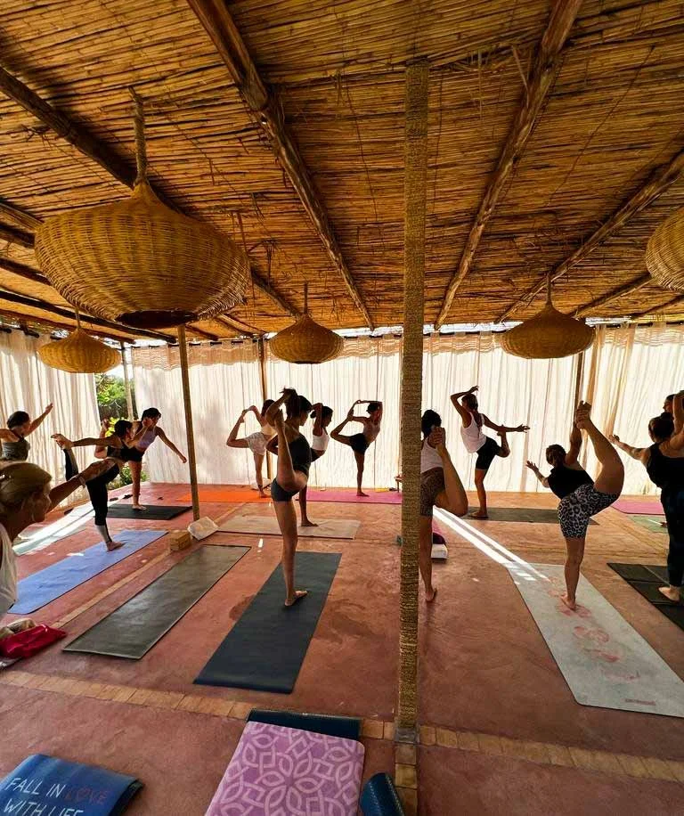 Group yoga practice in an open-air studio during a yoga retreat in Morocco.