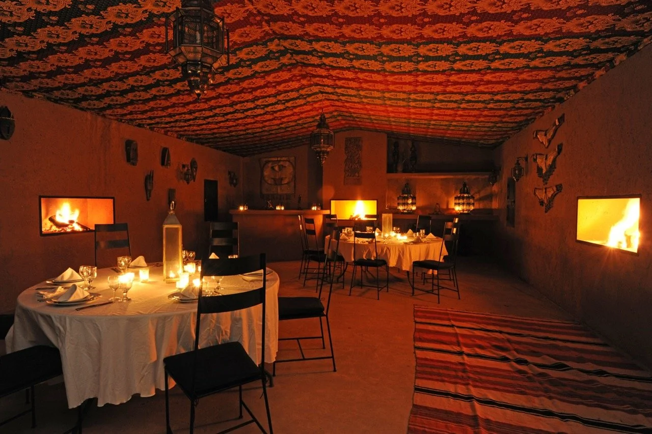 Atmospheric candlelit dining room at the boutique retreat venue near Marrakech, Morocco.