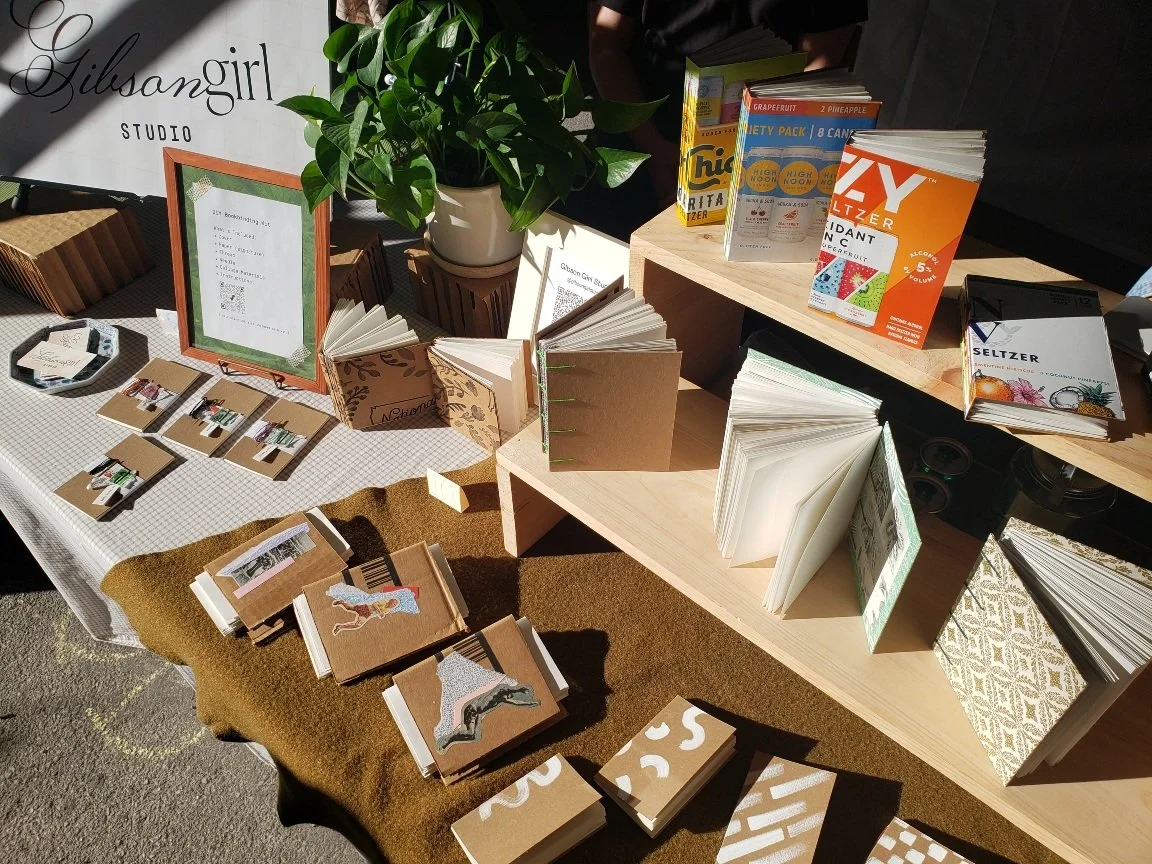 Photograph of vendor table displaying books for Gibson Girl Studio.
