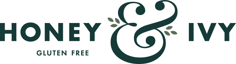 Draft of Honey & Ivy logo with dark green text and a large ampersand with greenery.