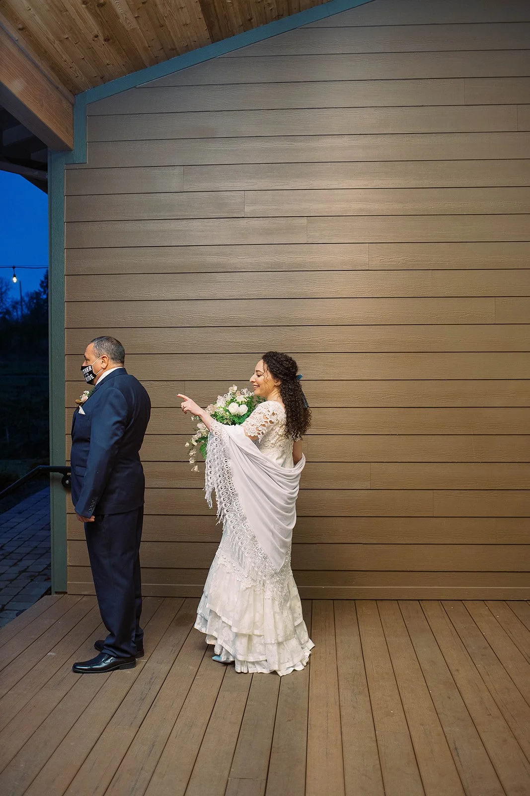 Bride approaches her father from behind for a first look before the evening wedding ceremony.