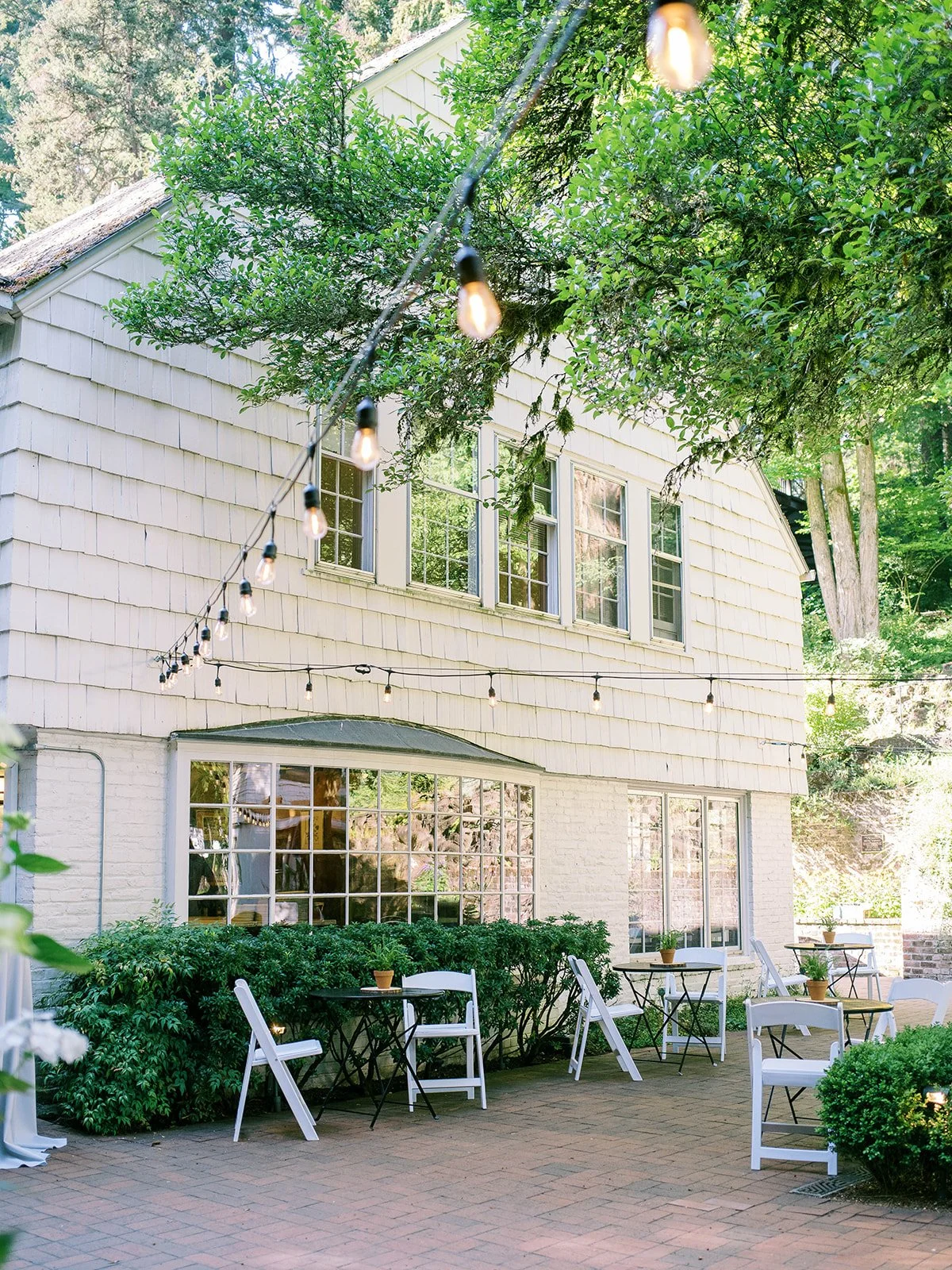 Patio seating and string lights outside a garden building at Leach Botanical Garden.