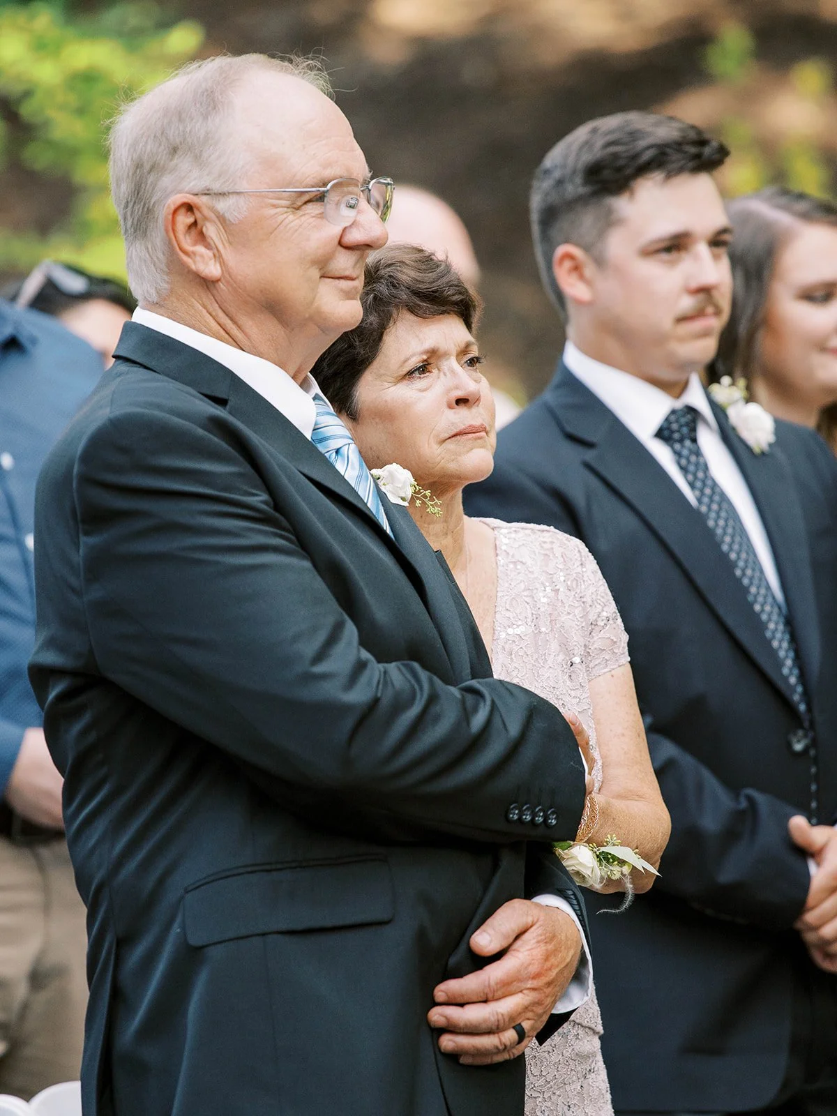Parents of the bride sharing emotional ceremony moment during outdoor garden wedding.